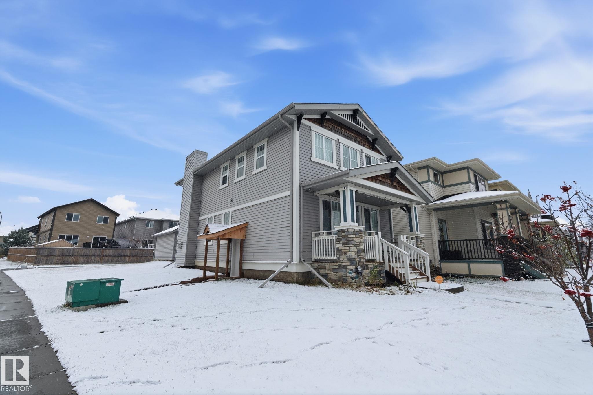 View of snowy exterior featuring covered porch and a garage - 1511 Secord Rd, Edmonton, AB - Outdoor