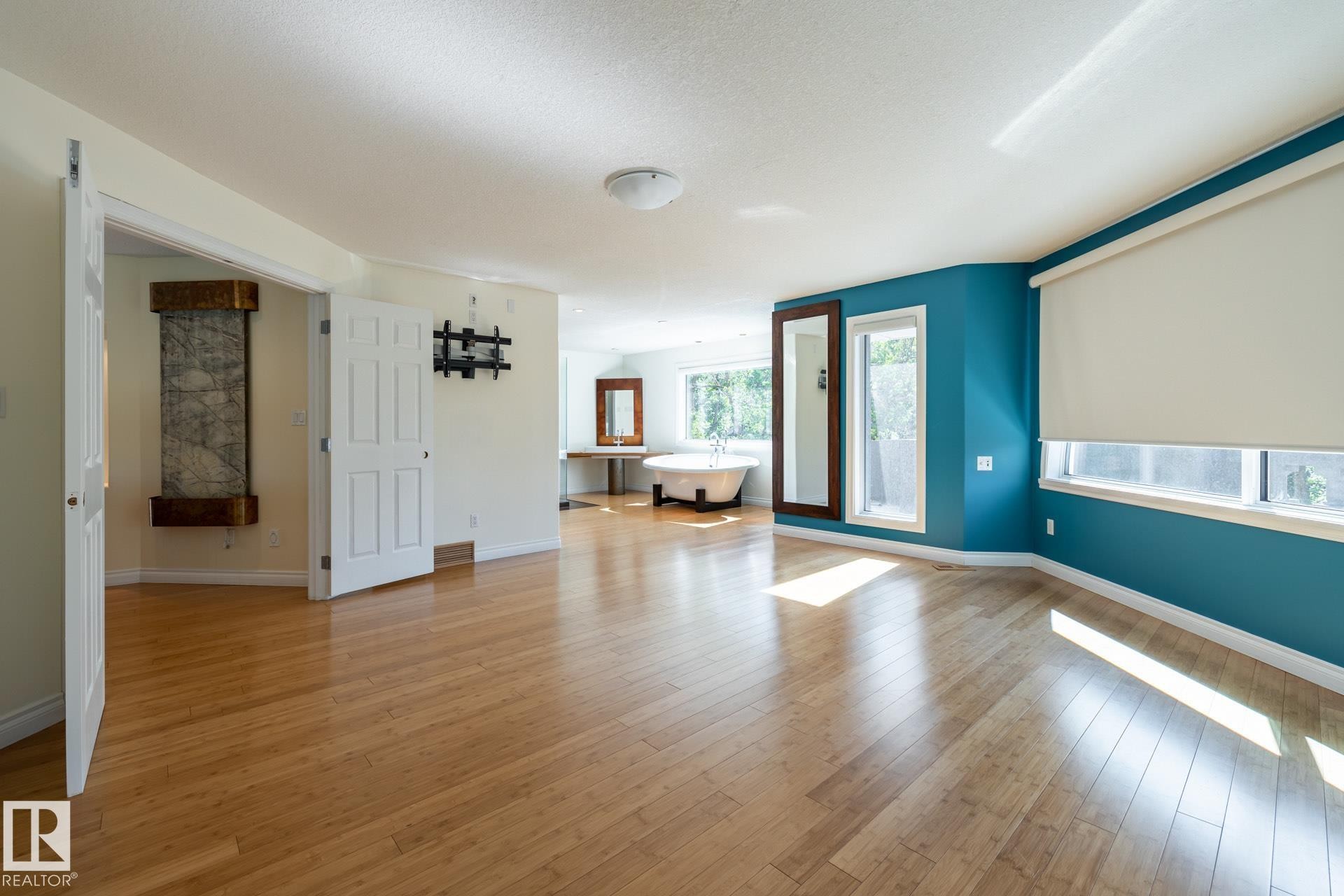 Spare room featuring light wood-style flooring and a textured ceiling - 12428 103 Avenue Nw, Edmonton, AB - Indoor