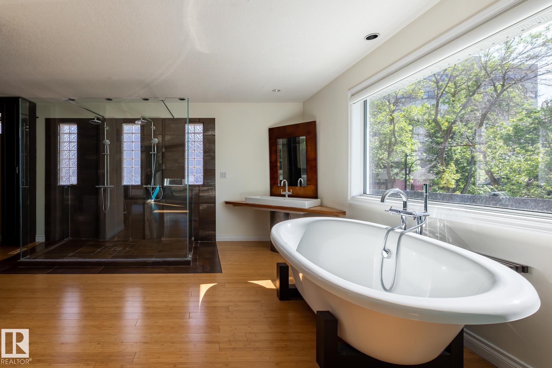 Bathroom with a freestanding bath, a stall shower, healthy amount of natural light, and hardwood / wood-style flooring - 12428 103 Avenue Nw, Edmonton, AB - Indoor Photo Showing Bathroom