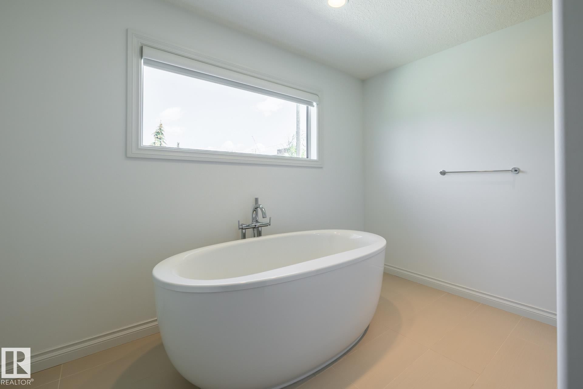 Full bath featuring baseboards and a freestanding bath - 12428 103 Avenue Nw, Edmonton, AB - Indoor Photo Showing Bathroom