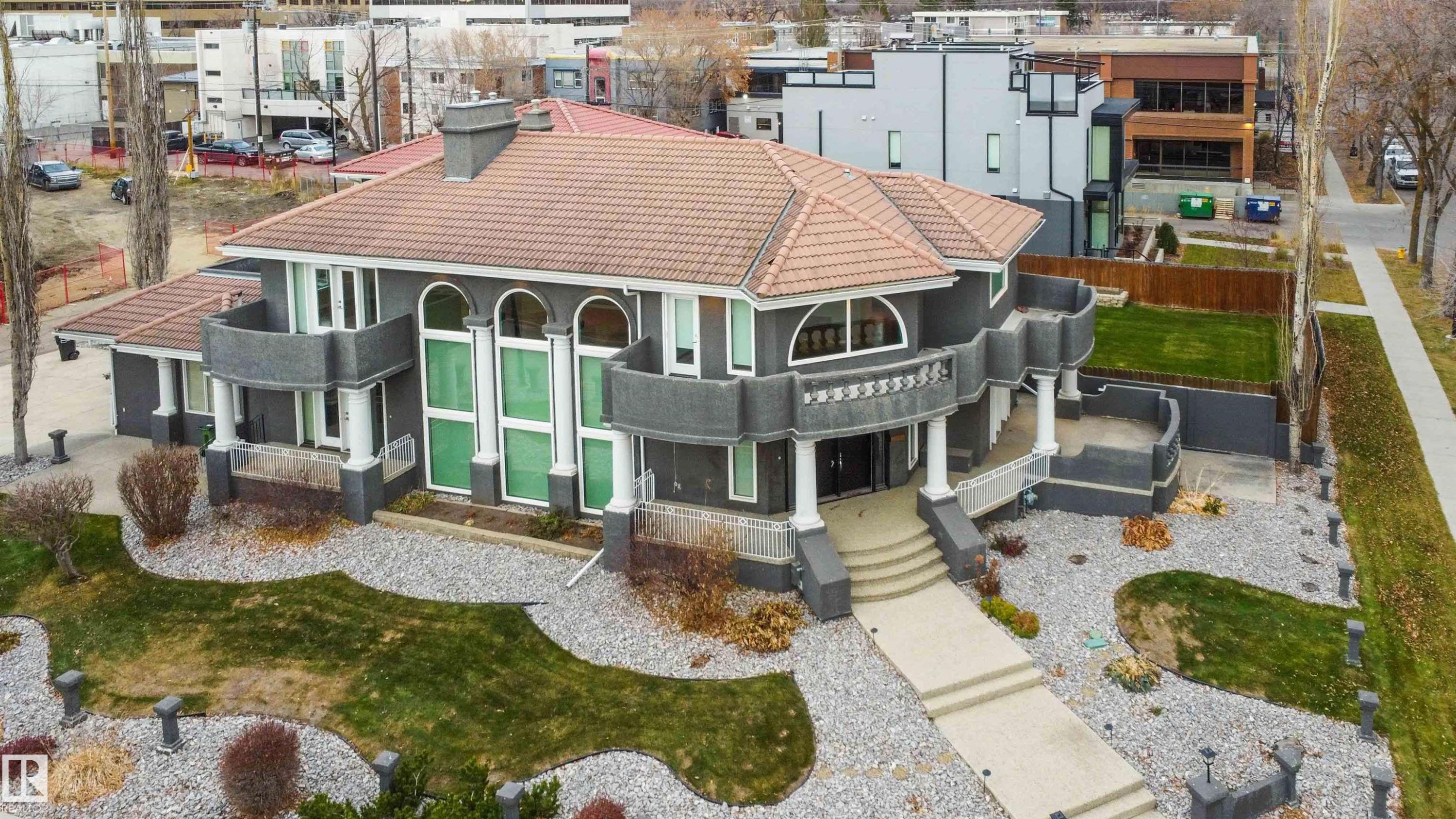 Back of house featuring a tiled roof, a porch, and stucco siding - 12428 103 Avenue Nw, Edmonton, AB - Outdoor
