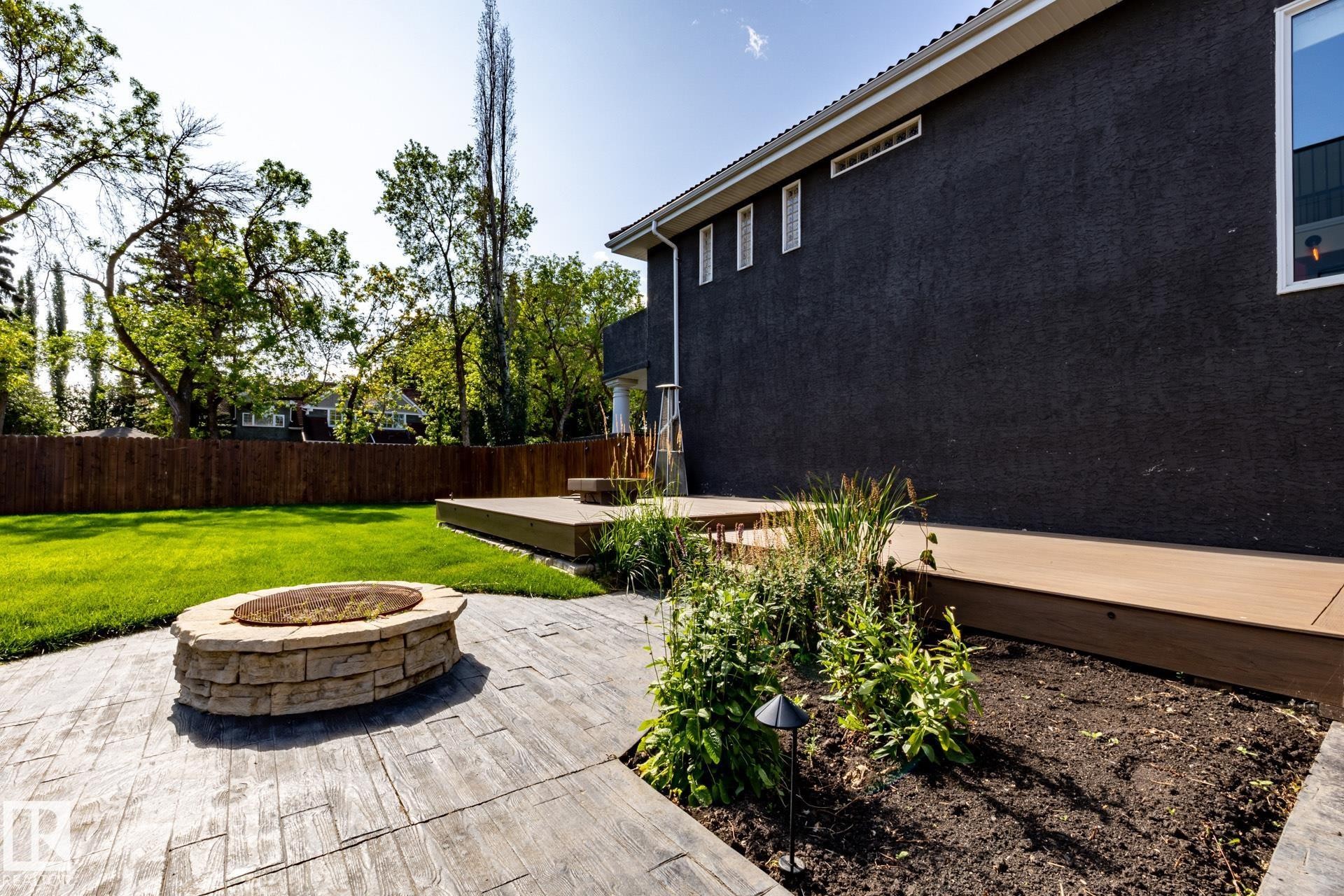 Fenced backyard with an outdoor fire pit and a wooden deck - 12428 103 Avenue Nw, Edmonton, AB - Outdoor