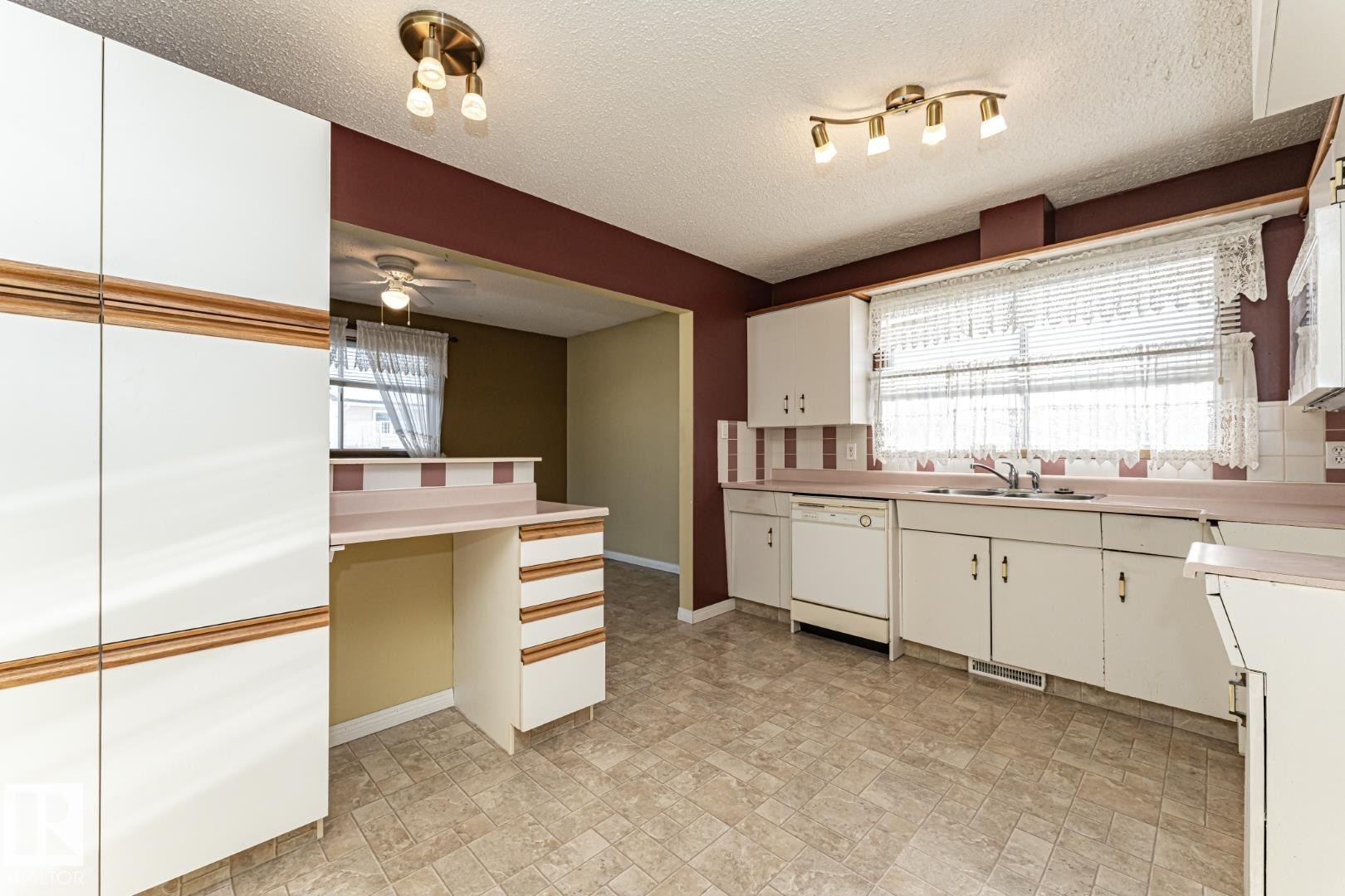 Kitchen featuring light countertops, white appliances, white cabinets, a textured ceiling, and ceiling fan - 10207 165 Avenue, Edmonton, AB - Indoor Photo Showing Kitchen With Double Sink