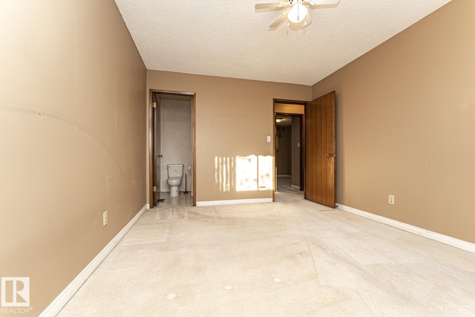 Unfurnished bedroom with carpet, a textured ceiling, connected bathroom, and ceiling fan - 10207 165 Avenue, Edmonton, AB - Indoor Photo Showing Other Room