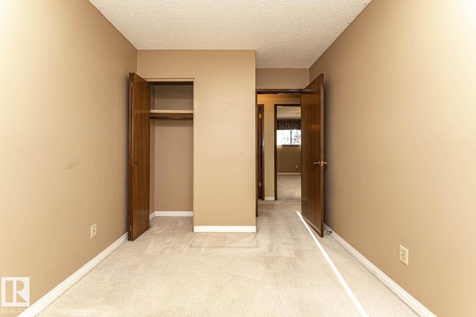 Unfurnished bedroom with a textured ceiling, carpet floors, and a closet - 10207 165 Avenue, Edmonton, AB - Indoor Photo Showing Other Room