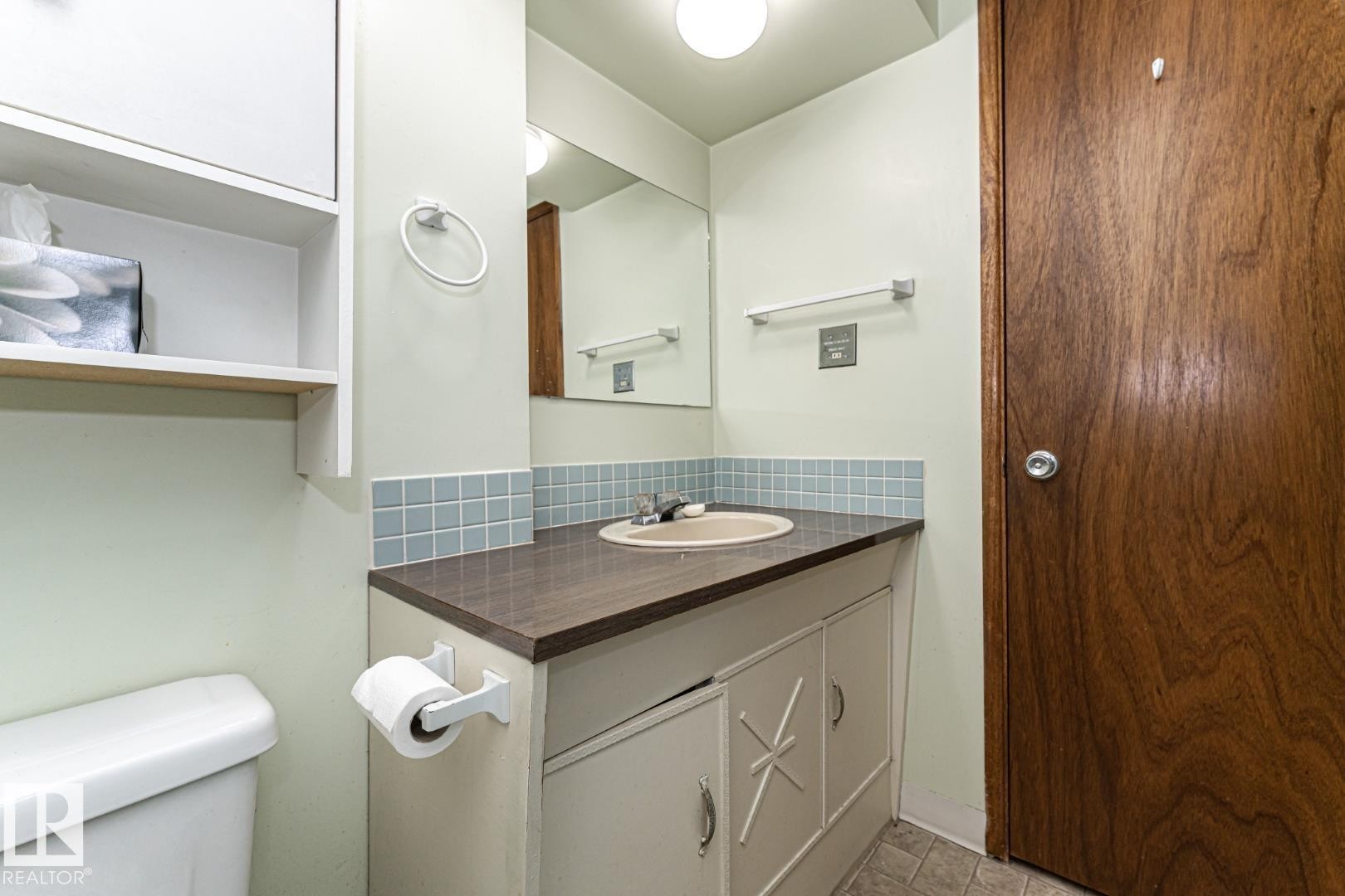 Half bathroom featuring vanity and backsplash - 10207 165 Avenue, Edmonton, AB - Indoor Photo Showing Bathroom