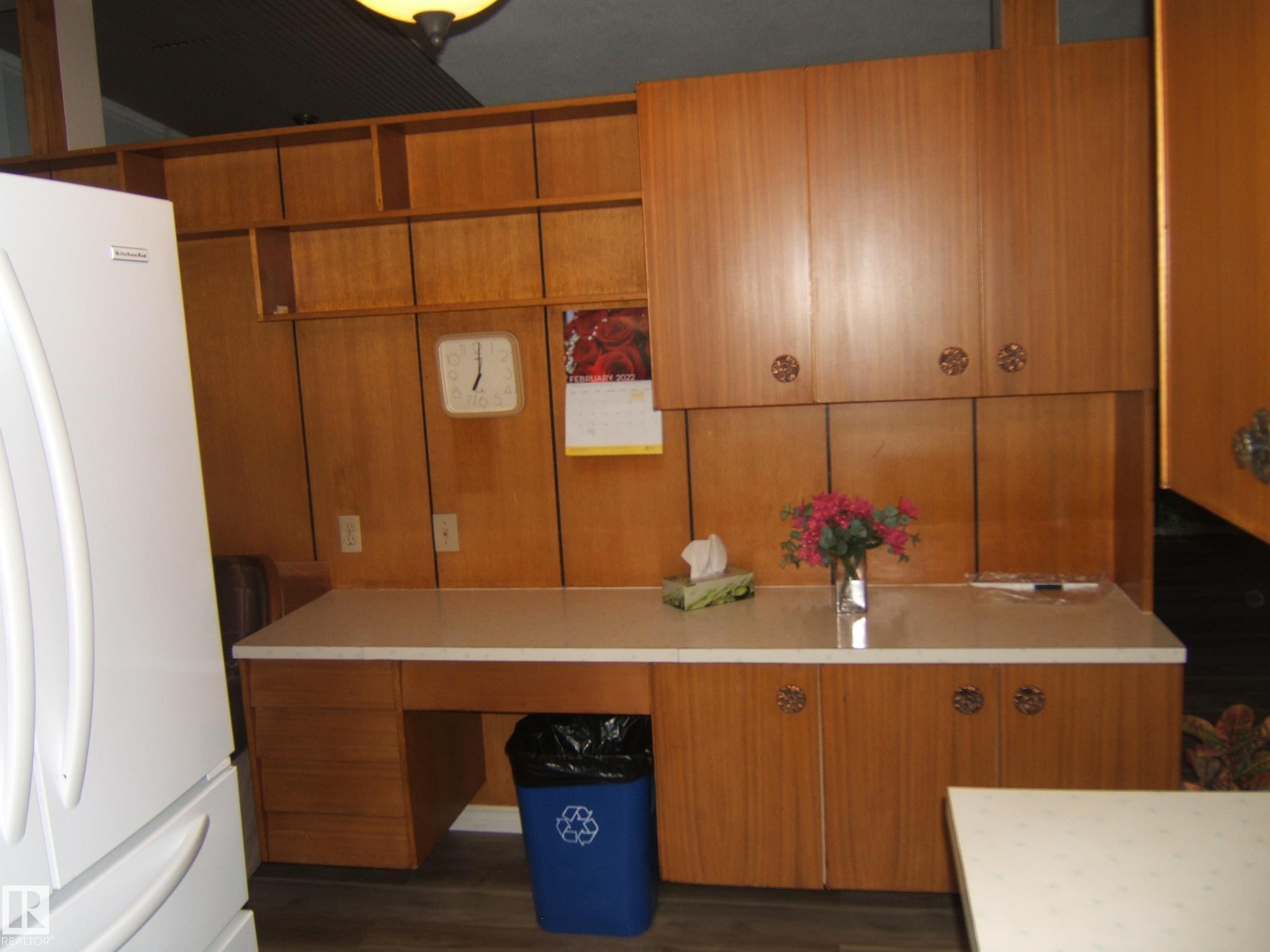 Kitchen with freestanding refrigerator and brown cabinetry - 4910 53 Avenue, Willingdon, AB