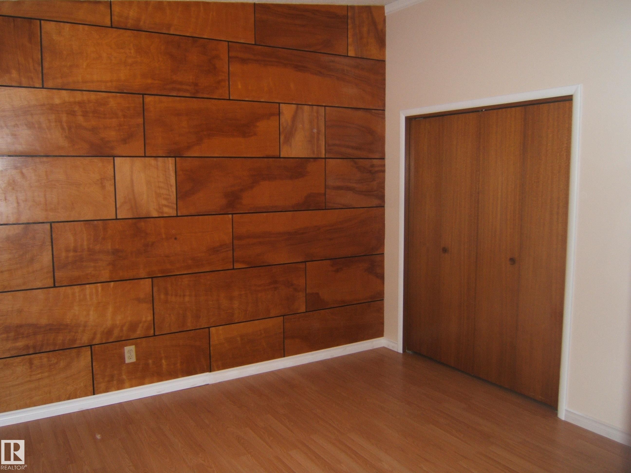 Unfurnished bedroom featuring wood finished floors and a closet - 4910 53 Avenue, Willingdon, AB