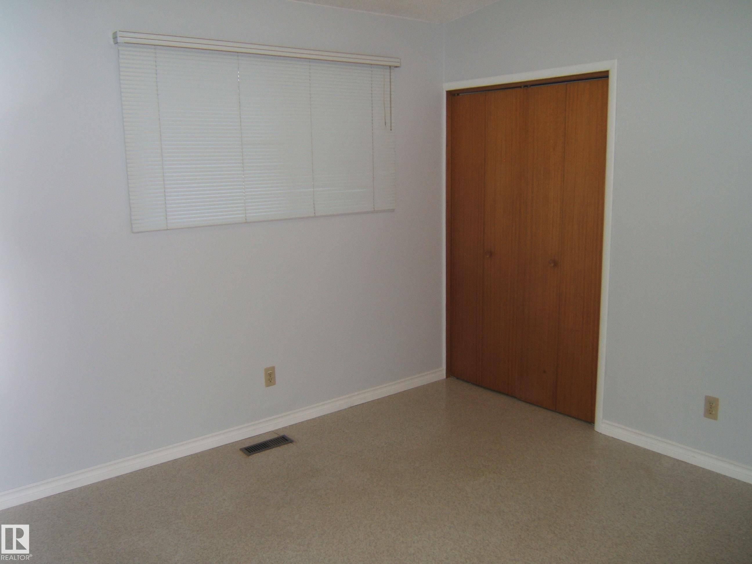 Unfurnished bedroom with baseboards and a closet - 4910 53 Avenue, Willingdon, AB