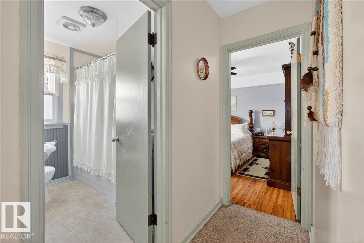Corridor featuring baseboards and light colored carpet - 11630 71 Street, Edmonton, AB - Indoor