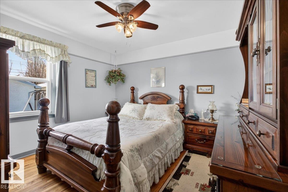 Bedroom with wood finished floors and a ceiling fan - 11630 71 Street, Edmonton, AB - Indoor Photo Showing Bedroom