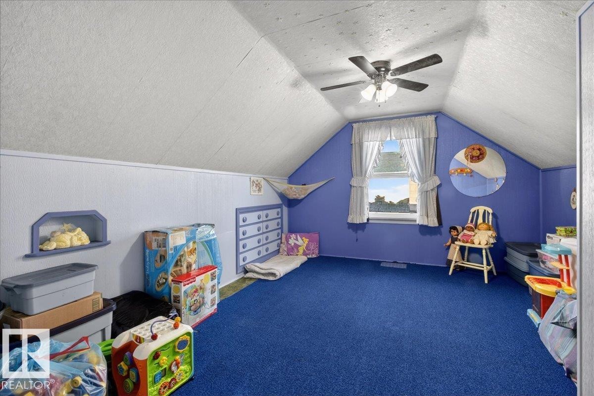 Playroom featuring lofted ceiling, a textured ceiling, carpet flooring, and a ceiling fan - 11630 71 Street, Edmonton, AB - Indoor Photo Showing Other Room