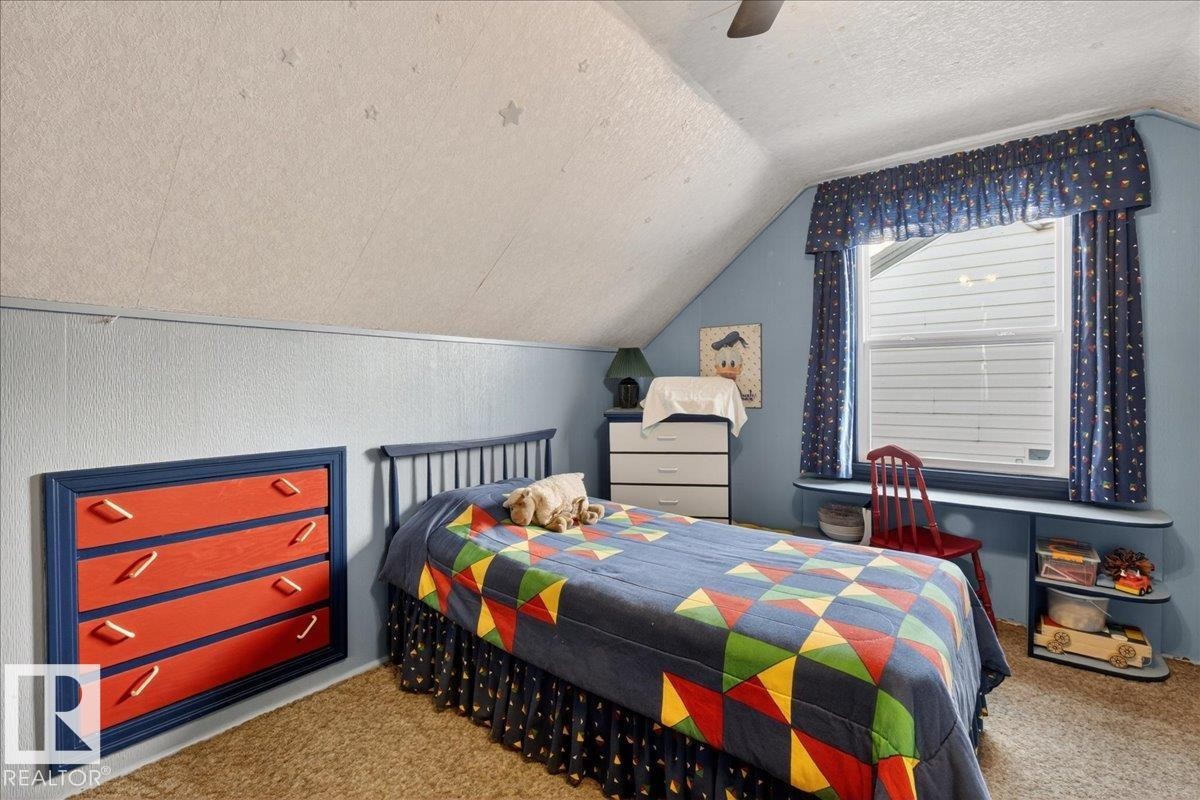 Carpeted bedroom with vaulted ceiling, a textured ceiling, and a ceiling fan - 11630 71 Street, Edmonton, AB - Indoor Photo Showing Bedroom