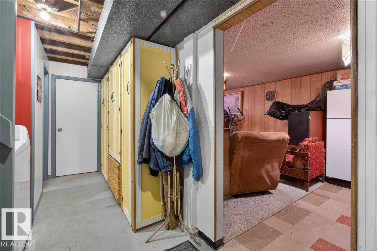 Hall featuring wooden walls, washer / dryer, and light floors - 11630 71 Street, Edmonton, AB - Indoor Photo Showing Other Room
