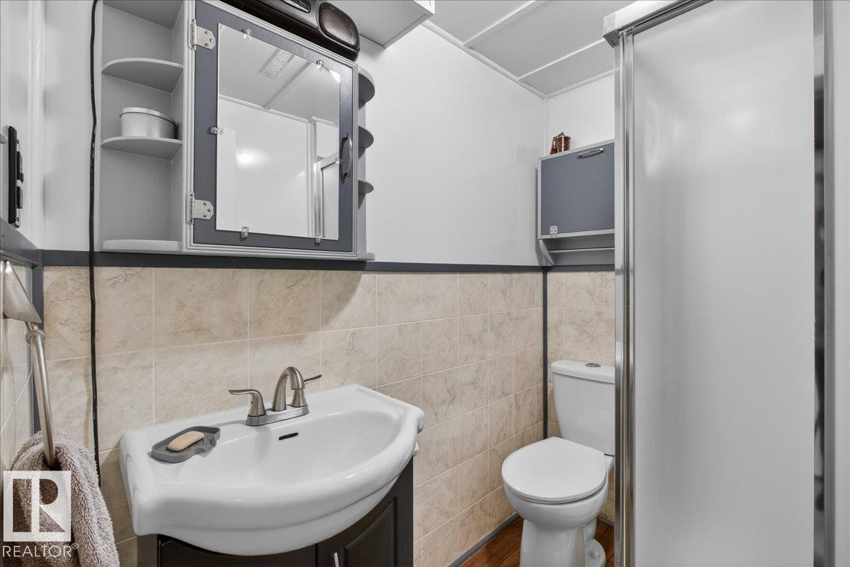 Bathroom with vanity, tile walls, and a wainscoted wall - 11630 71 Street, Edmonton, AB - Indoor Photo Showing Bathroom