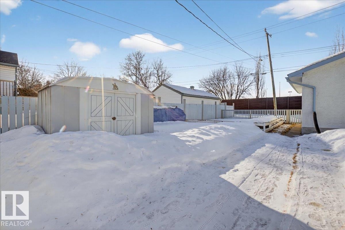 Snowy yard with a fenced backyard and a storage shed - 11630 71 Street, Edmonton, AB - Outdoor