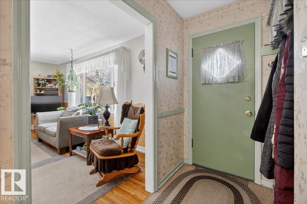 Entrance foyer featuring wood finished floors and wallpapered walls - 11630 71 Street, Edmonton, AB - Indoor Photo Showing Other Room