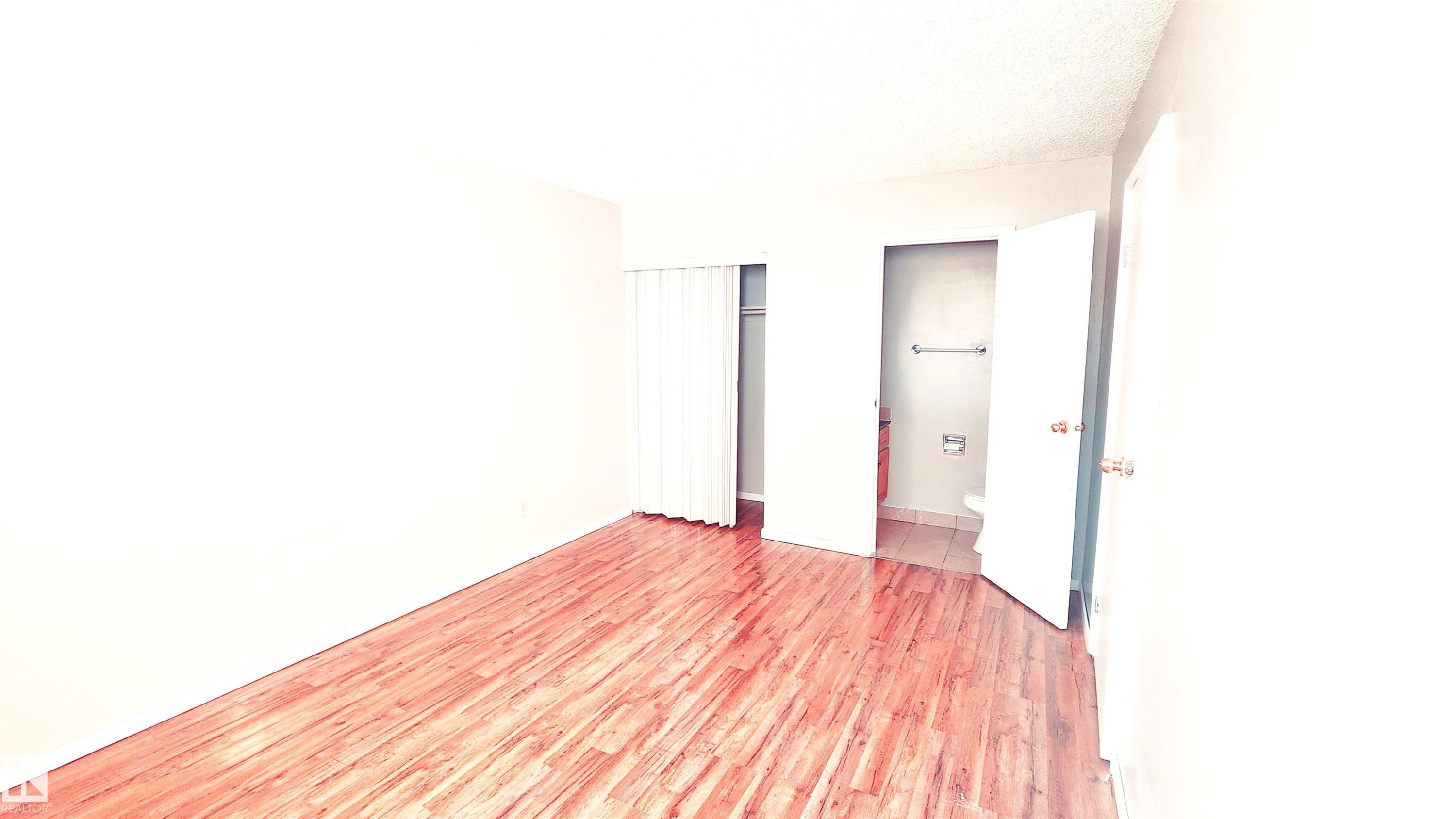 Unfurnished bedroom featuring light wood-style floors and a closet - 2 11265 31 Avenue, Edmonton, AB - Indoor Photo Showing Other Room