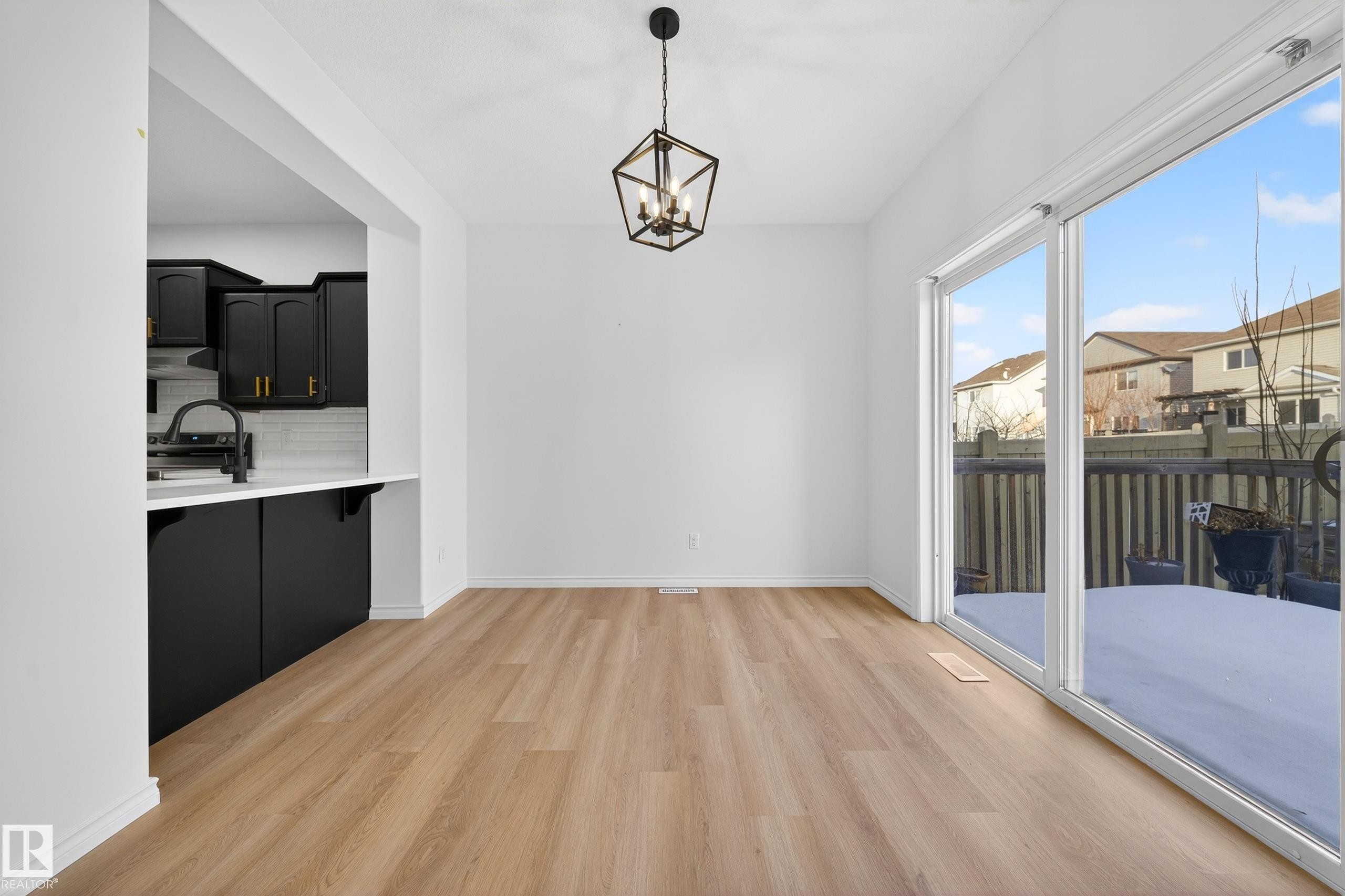 Unfurnished dining area featuring light wood-style flooring and a chandelier - 1741 63A Street, Edmonton, AB - Indoor Photo Showing Other Room