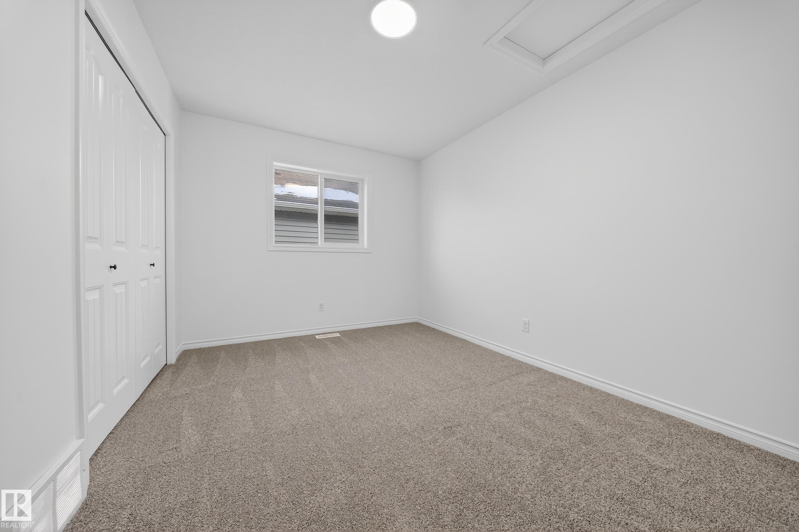Unfurnished bedroom with light carpet, a closet, and vaulted ceiling - 1741 63A Street, Edmonton, AB - Indoor Photo Showing Other Room
