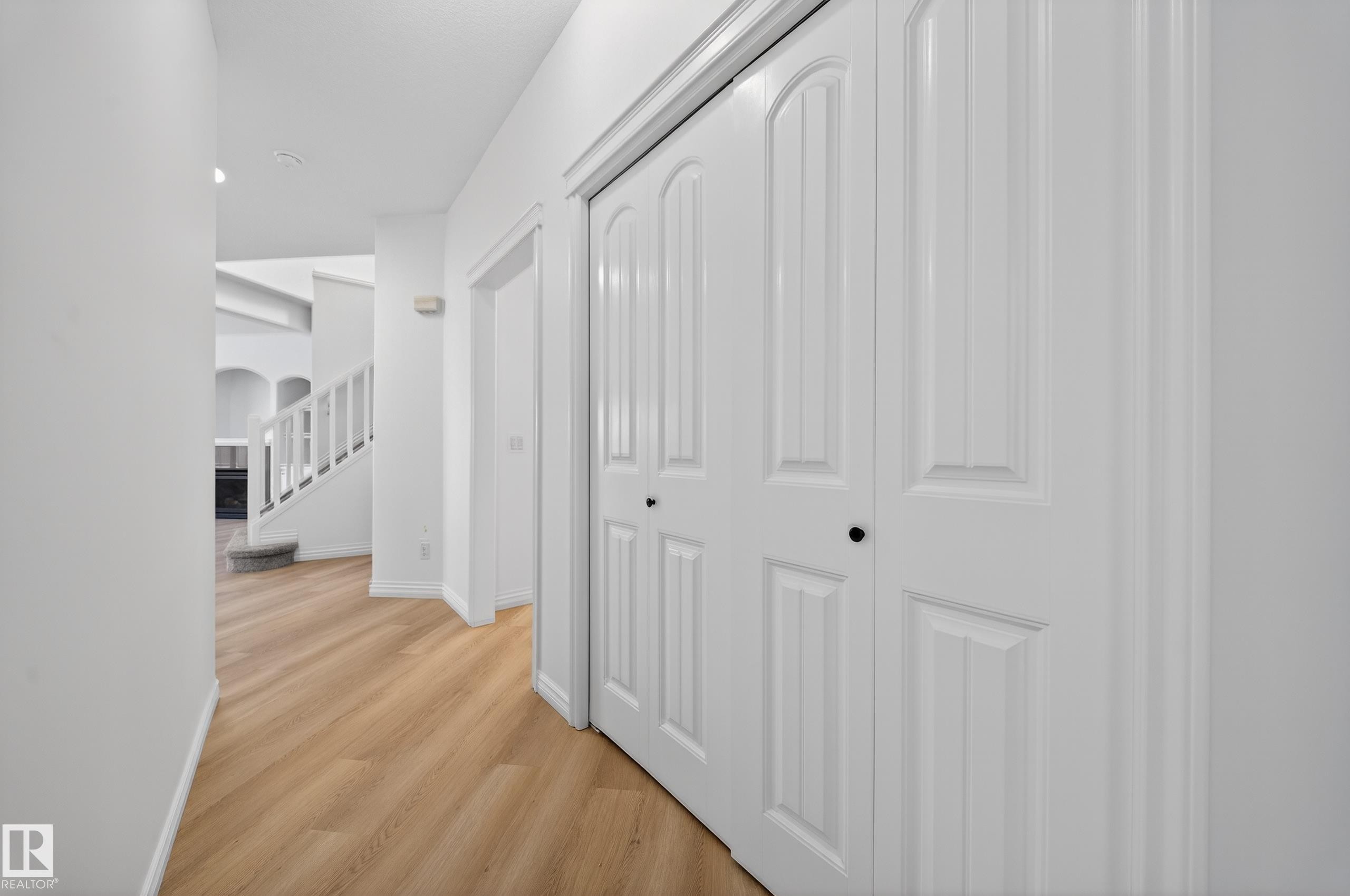 Hall featuring light wood-type flooring, arched walkways, and stairs - 1741 63A Street, Edmonton, AB - Indoor Photo Showing Other Room