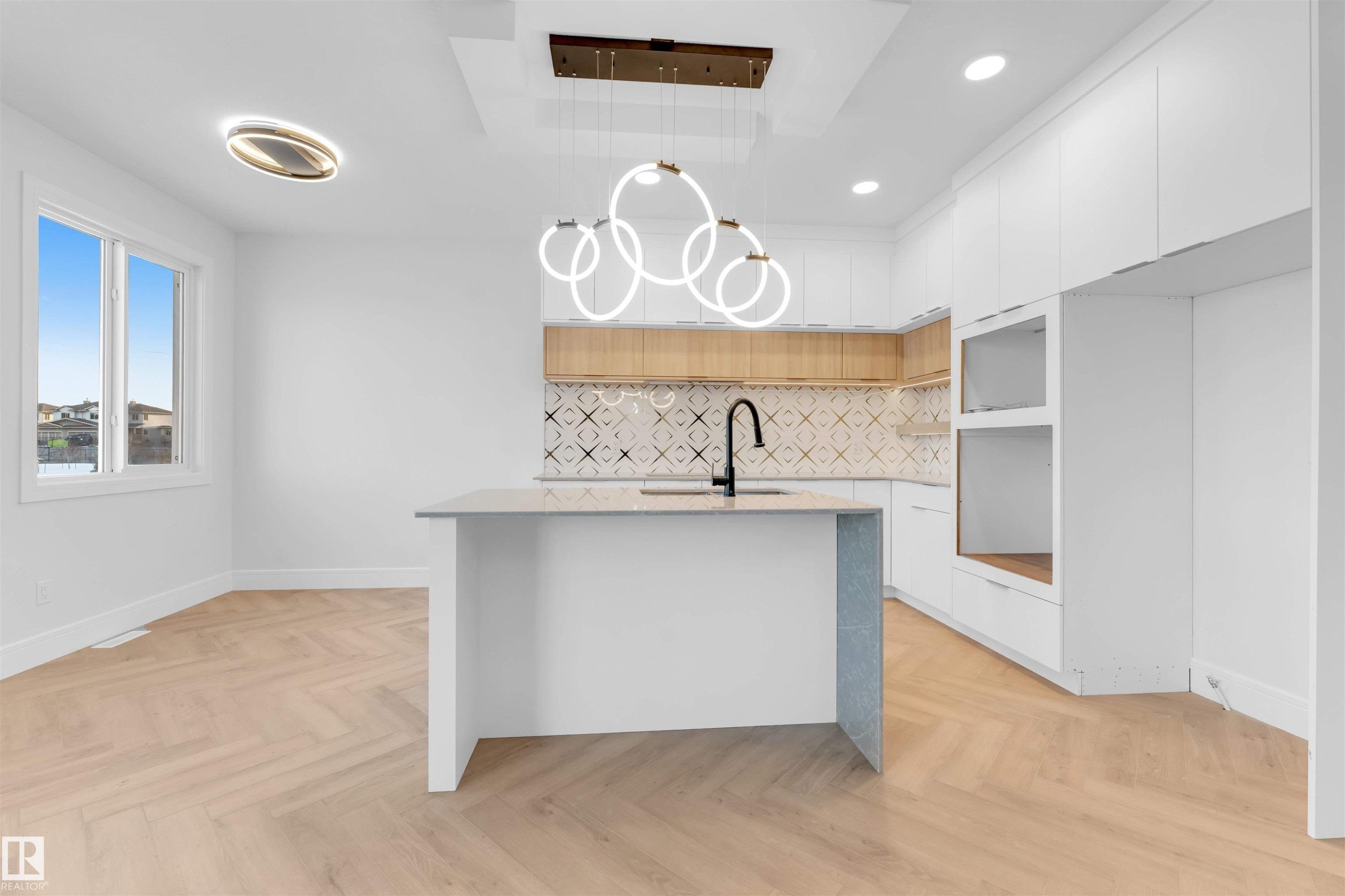 Kitchen featuring modern cabinets, a kitchen island with sink, light stone countertops, white cabinetry, and recessed lighting - 150 Creekside Lane, Leduc, AB - Indoor Photo Showing Kitchen
