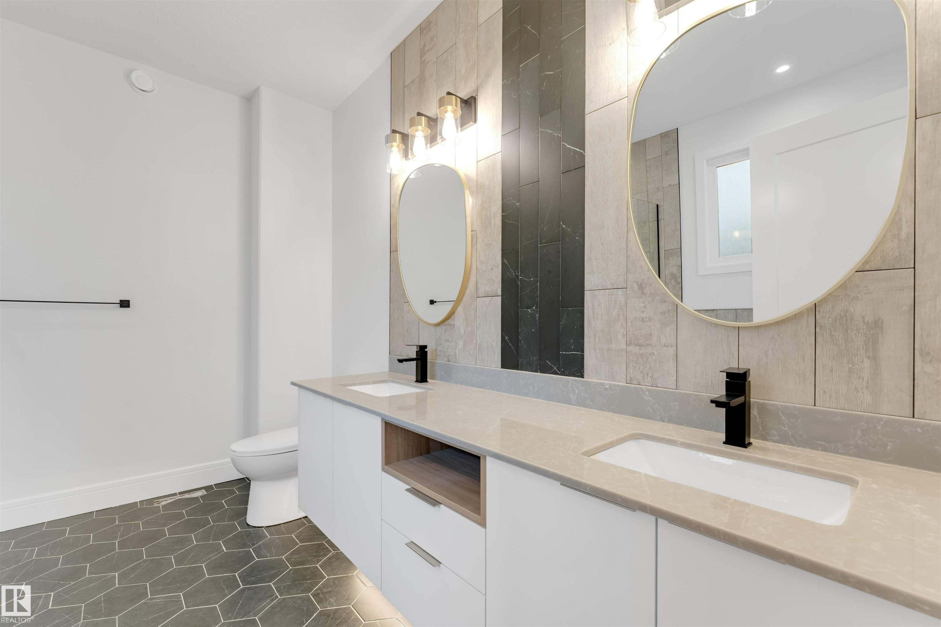 Full bathroom with double vanity, tile walls, and dark tile patterned flooring - 150 Creekside Lane, Leduc, AB - Indoor Photo Showing Bathroom
