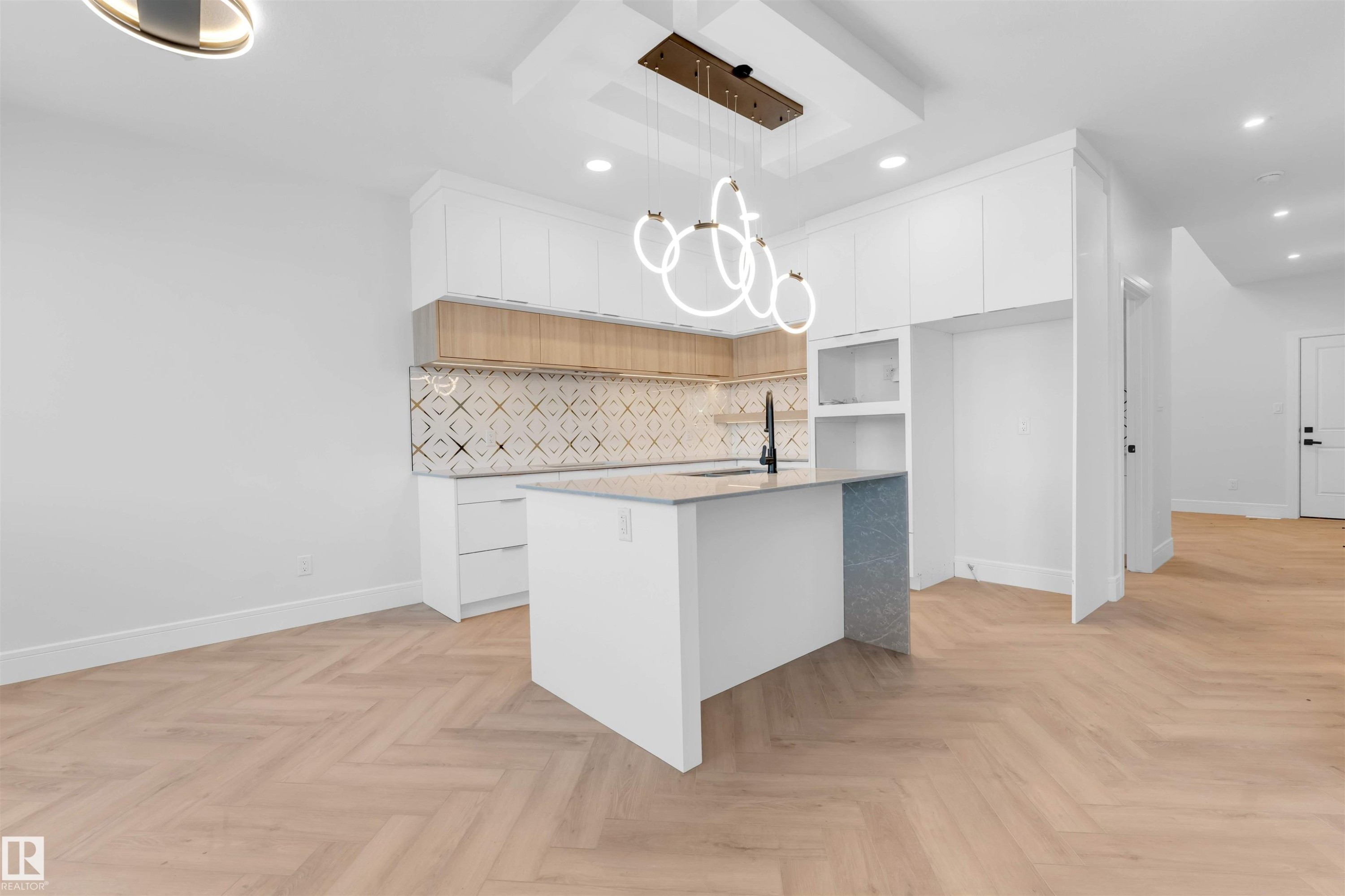 Kitchen featuring modern cabinets, white cabinetry, a kitchen island with sink, light stone countertops, and recessed lighting - 150 Creekside Lane, Leduc, AB - Indoor Photo Showing Kitchen