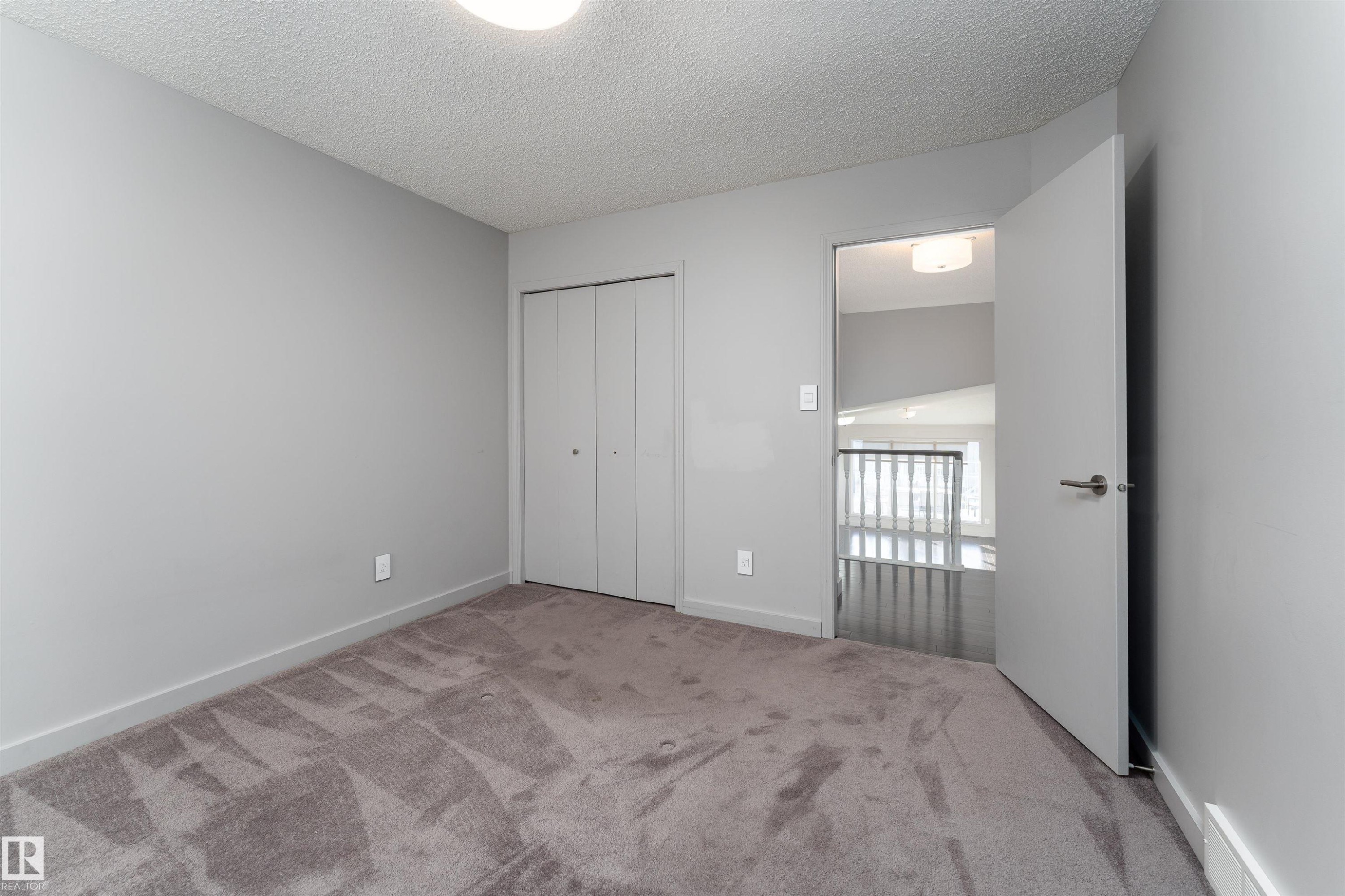 Unfurnished bedroom with carpet, a textured ceiling, and a closet - 174 Oeming Road, Edmonton, AB - Indoor Photo Showing Other Room