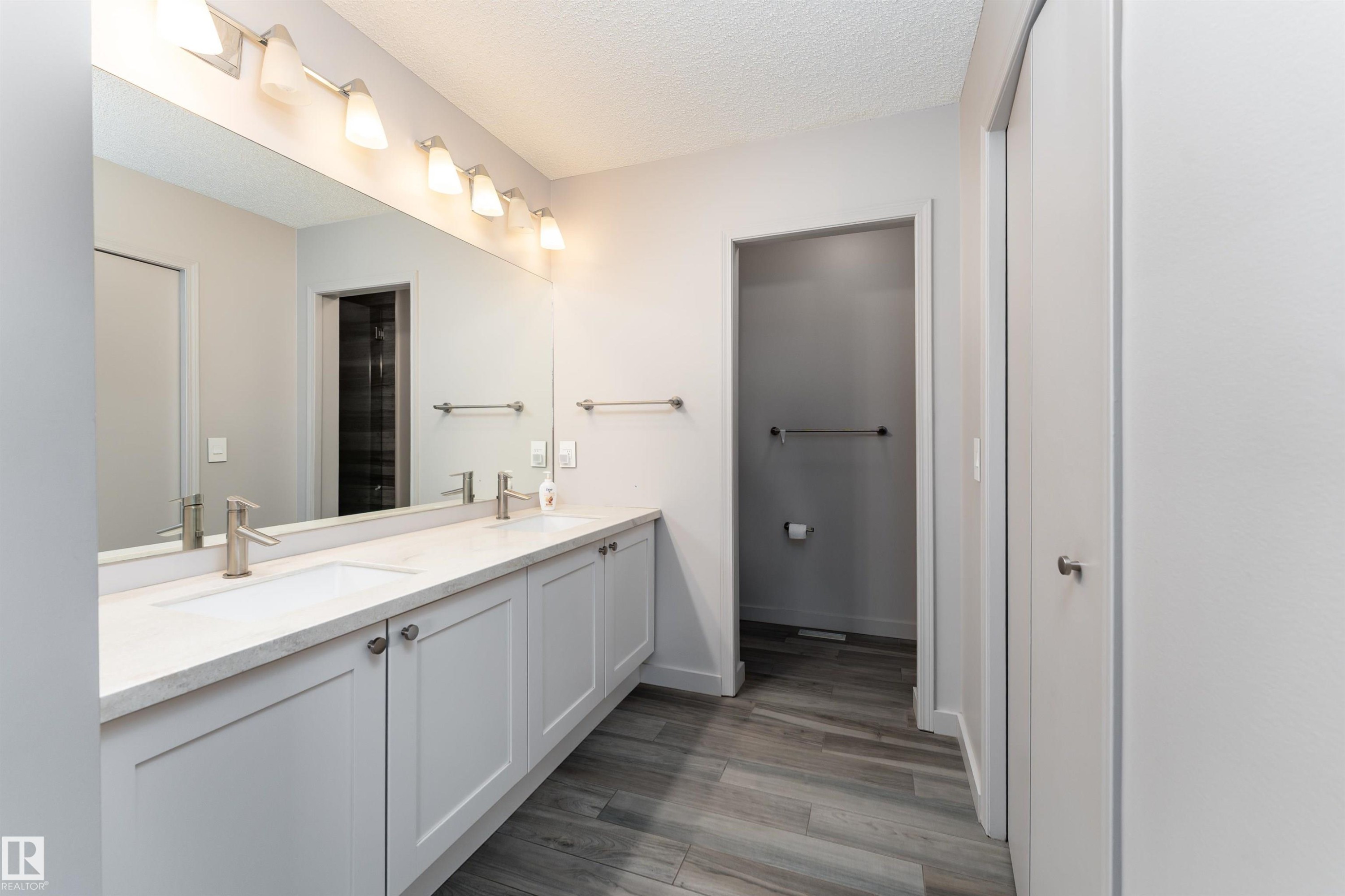 Full bathroom with double vanity, light wood finished floors, and a textured ceiling - 174 Oeming Road, Edmonton, AB - Indoor Photo Showing Bathroom