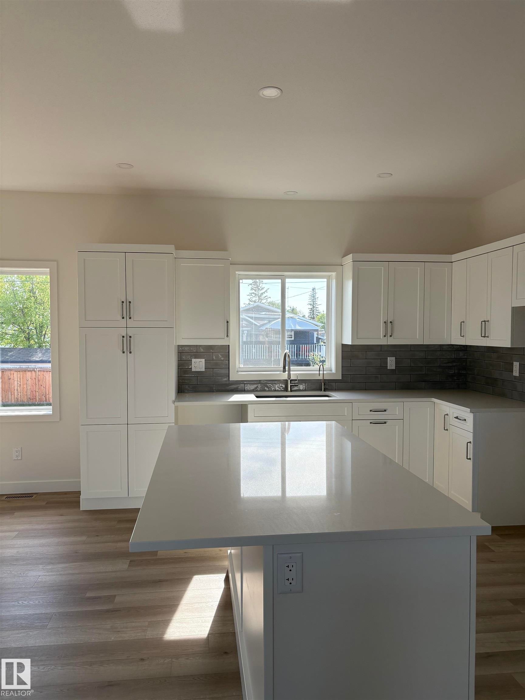 Kitchen featuring a large central island with a light-toned countertop - 6 4 Avenue, Hay Lakes, AB