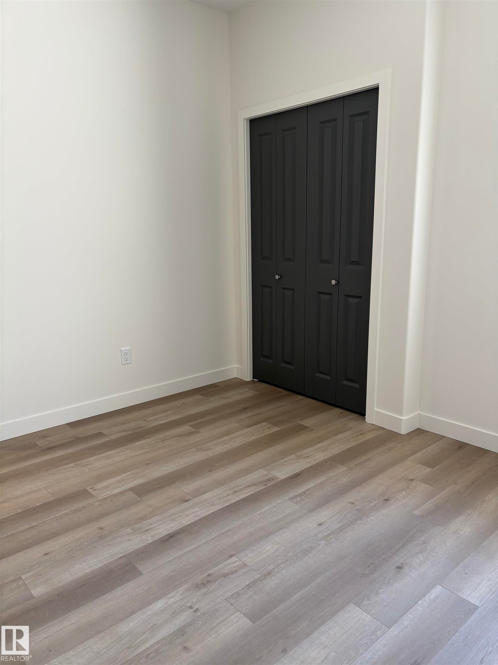 Room featuring light-toned wood-finish flooring, white baseboards, and white walls - 6 4 Avenue, Hay Lakes, AB