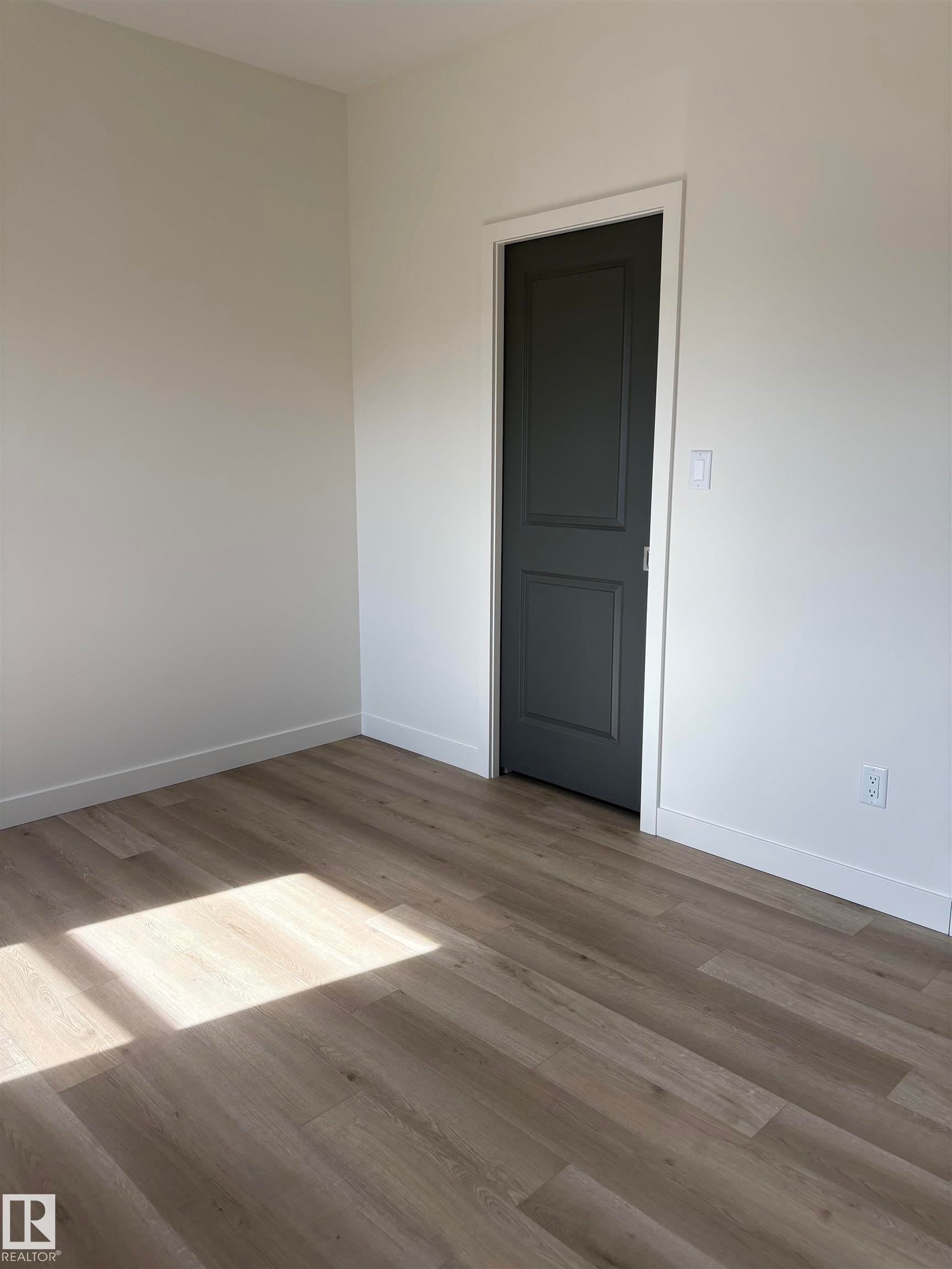 Light-toned wood-finish flooring complements the white walls and trim - 6 4 Avenue, Hay Lakes, AB