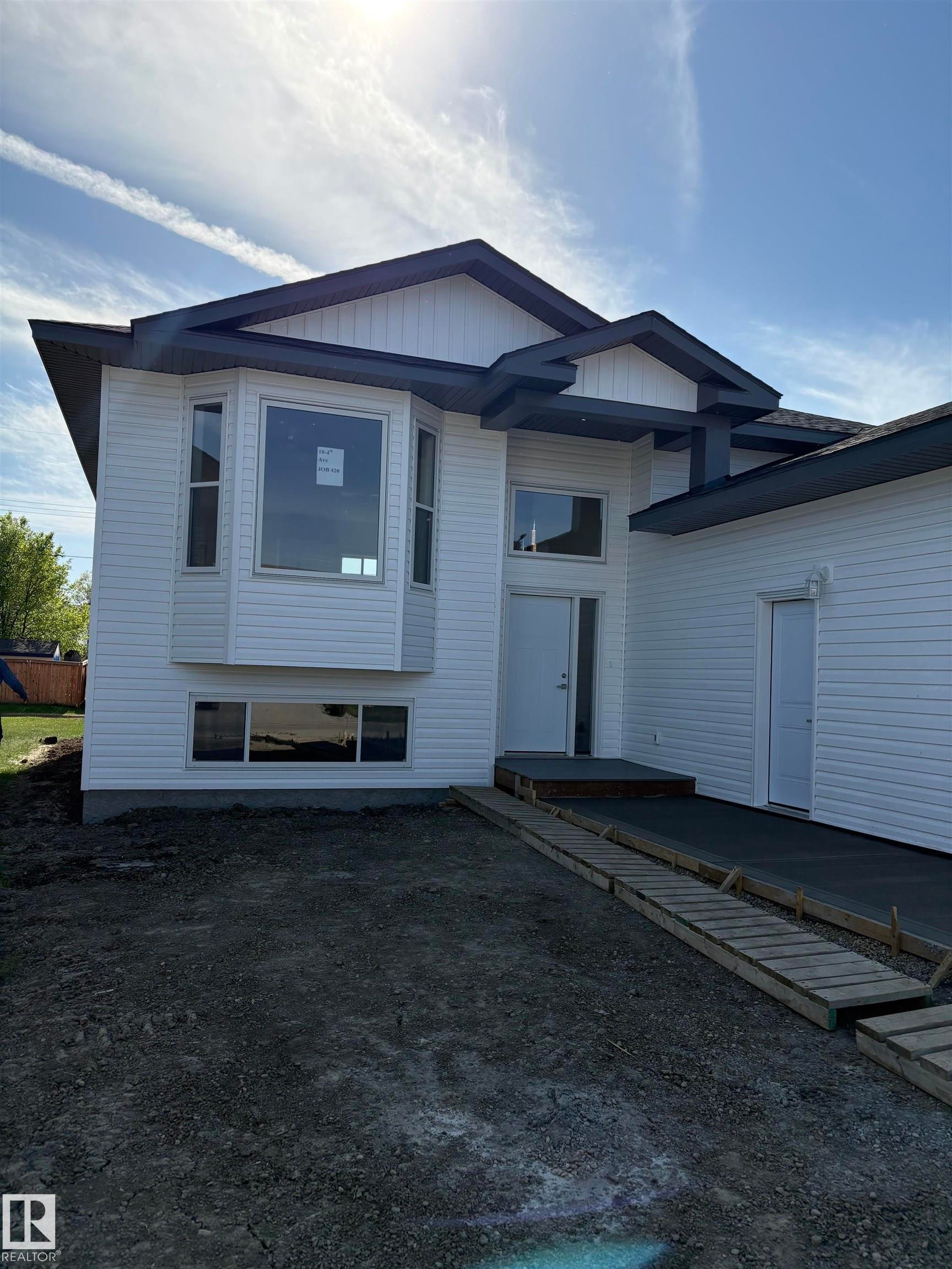 Modern exterior featuring white horizontal siding and contrasting dark trim - 6 4 Avenue, Hay Lakes, AB