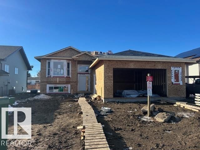 The property is a two-story structure with an attached garage, currently under construction with exposed wooden sheathing - 6 4 Avenue, Hay Lakes, AB