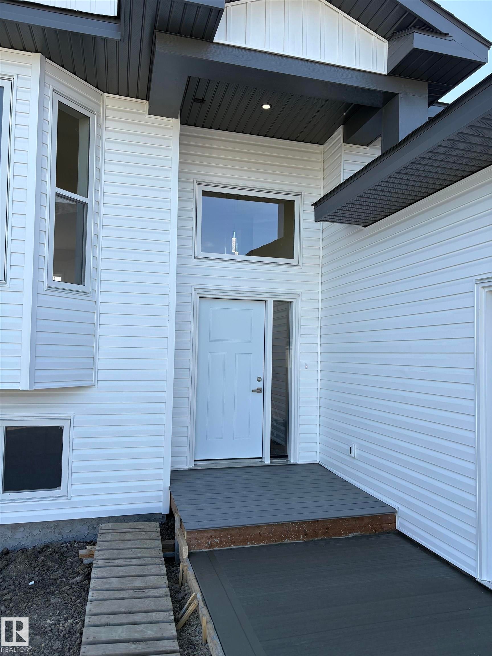 Contemporary exterior featuring white horizontal siding and dark gray trim - 6 4 Avenue, Hay Lakes, AB