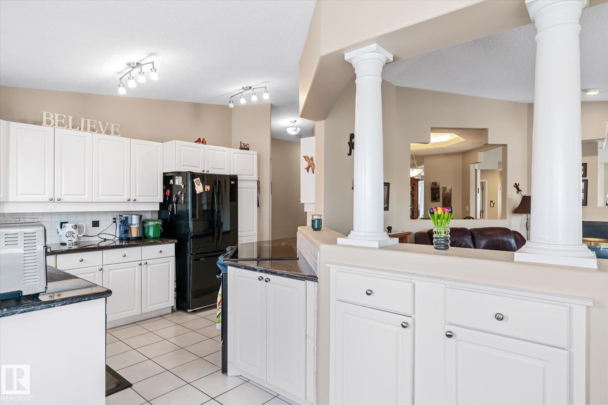 Kitchen with white cabinets, freestanding refrigerator, backsplash, and light tile patterned flooring - 7020 157 Avenue, Edmonton, AB - Indoor Photo Showing Kitchen