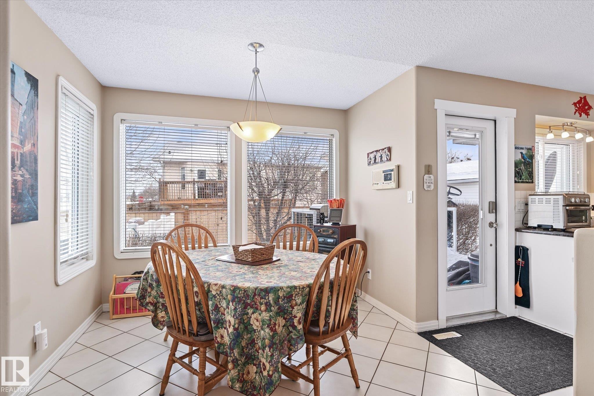 Dining space with a textured ceiling and light tile patterned floors - 7020 157 Avenue, Edmonton, AB - Indoor Photo Showing Dining Room
