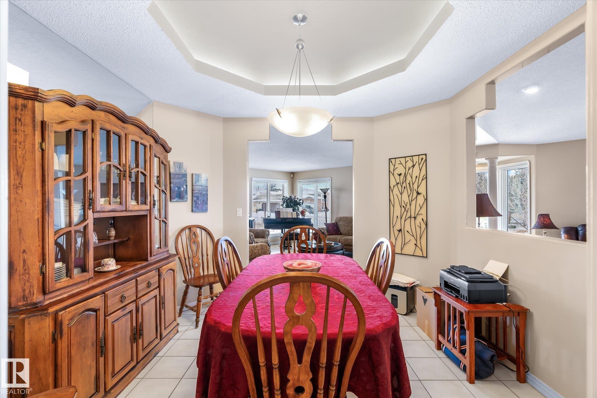 Dining room with light tile patterned floors, a raised ceiling, and a textured ceiling - 7020 157 Avenue, Edmonton, AB - Indoor Photo Showing Dining Room