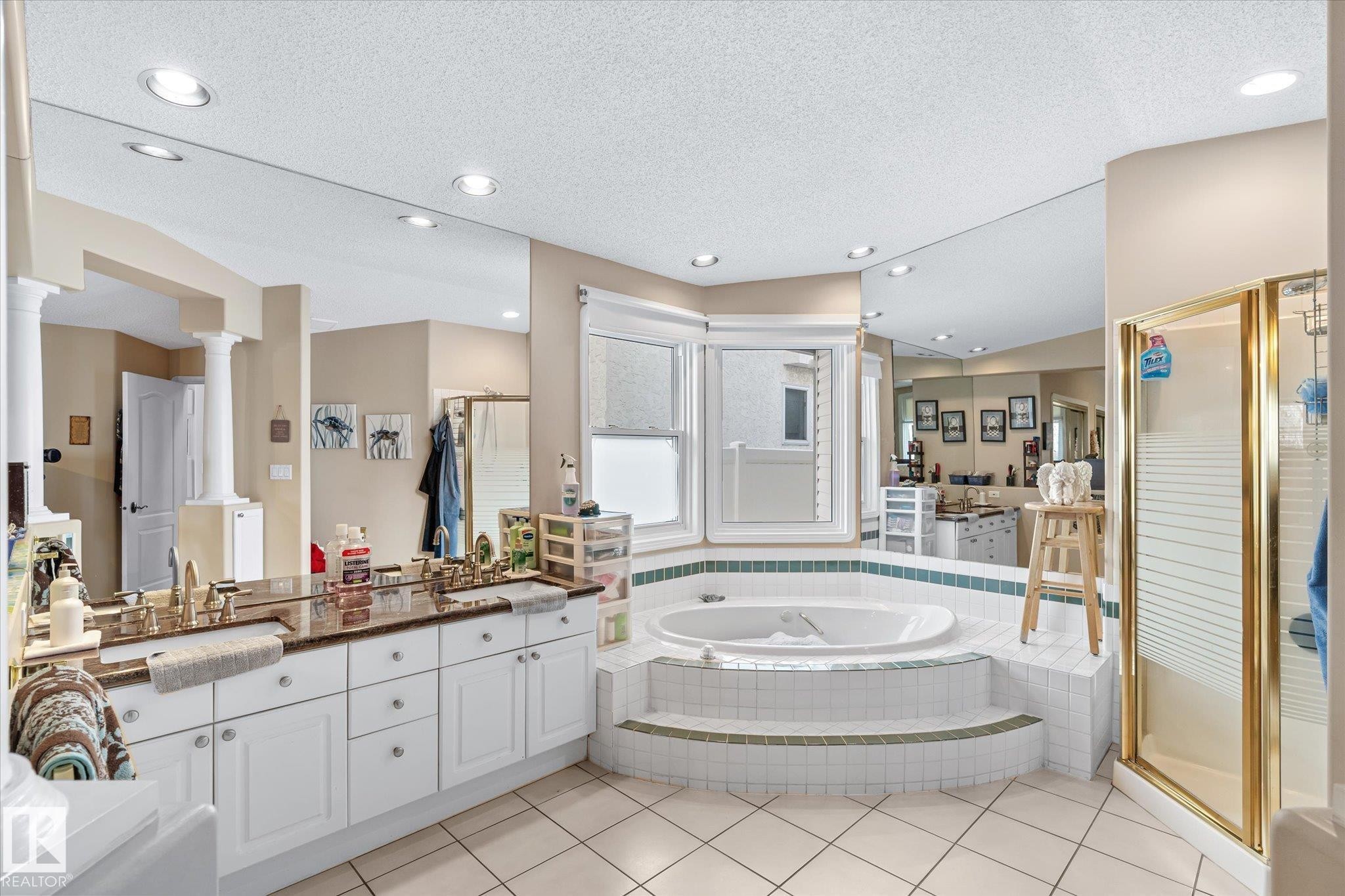 Bathroom with a bath, double vanity, a textured ceiling, a shower stall, and light tile patterned floors - 7020 157 Avenue, Edmonton, AB - Indoor