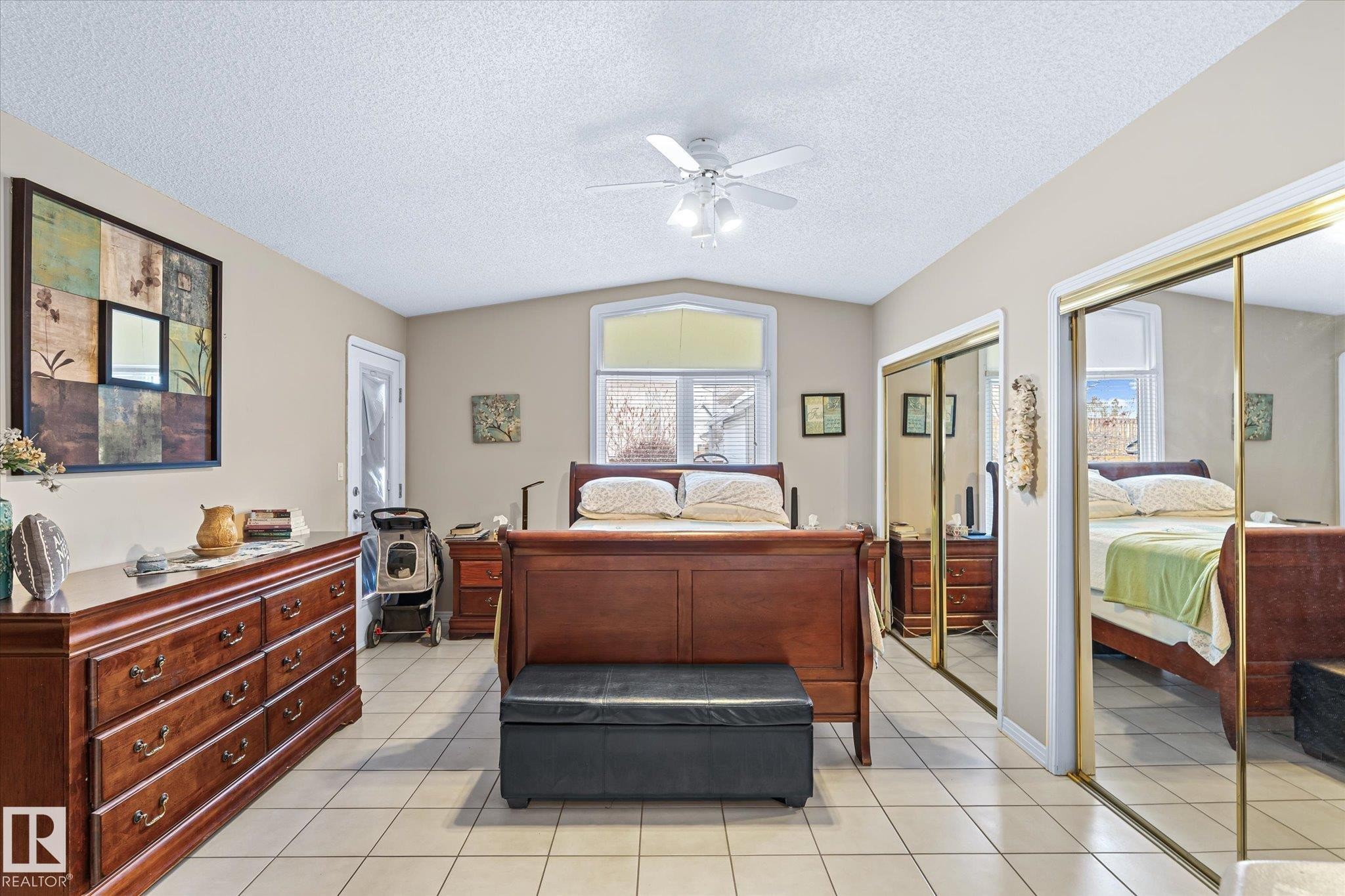 Bedroom featuring multiple closets, a textured ceiling, light tile patterned floors, a ceiling fan, and vaulted ceiling - 7020 157 Avenue, Edmonton, AB - Indoor Photo Showing Other Room