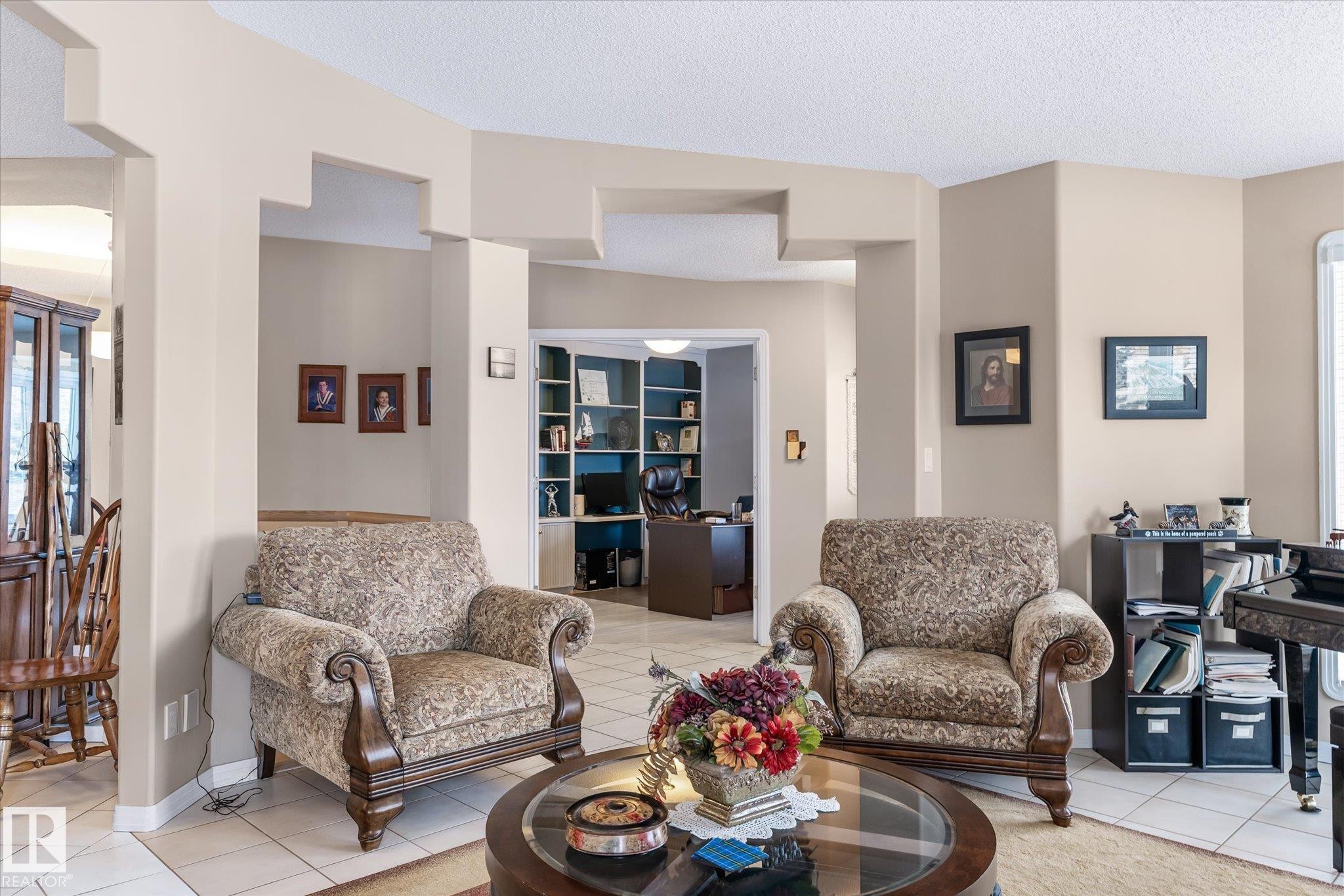 Living area with light tile patterned floors, a textured ceiling, and an office area - 7020 157 Avenue, Edmonton, AB - Indoor Photo Showing Living Room