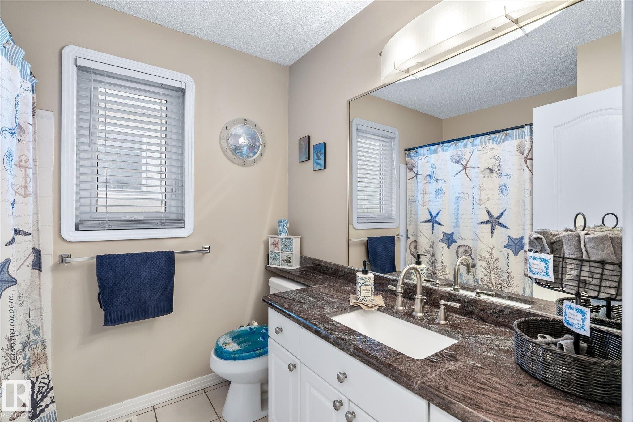 Full bathroom with vanity, a textured ceiling, light tile patterned floors, and a shower with curtain - 7020 157 Avenue, Edmonton, AB - Indoor Photo Showing Bathroom