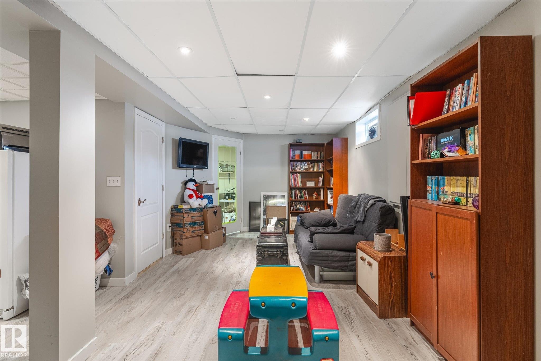 Recreation room with light wood-style floors, recessed lighting, and a paneled ceiling - 7020 157 Avenue, Edmonton, AB - Indoor