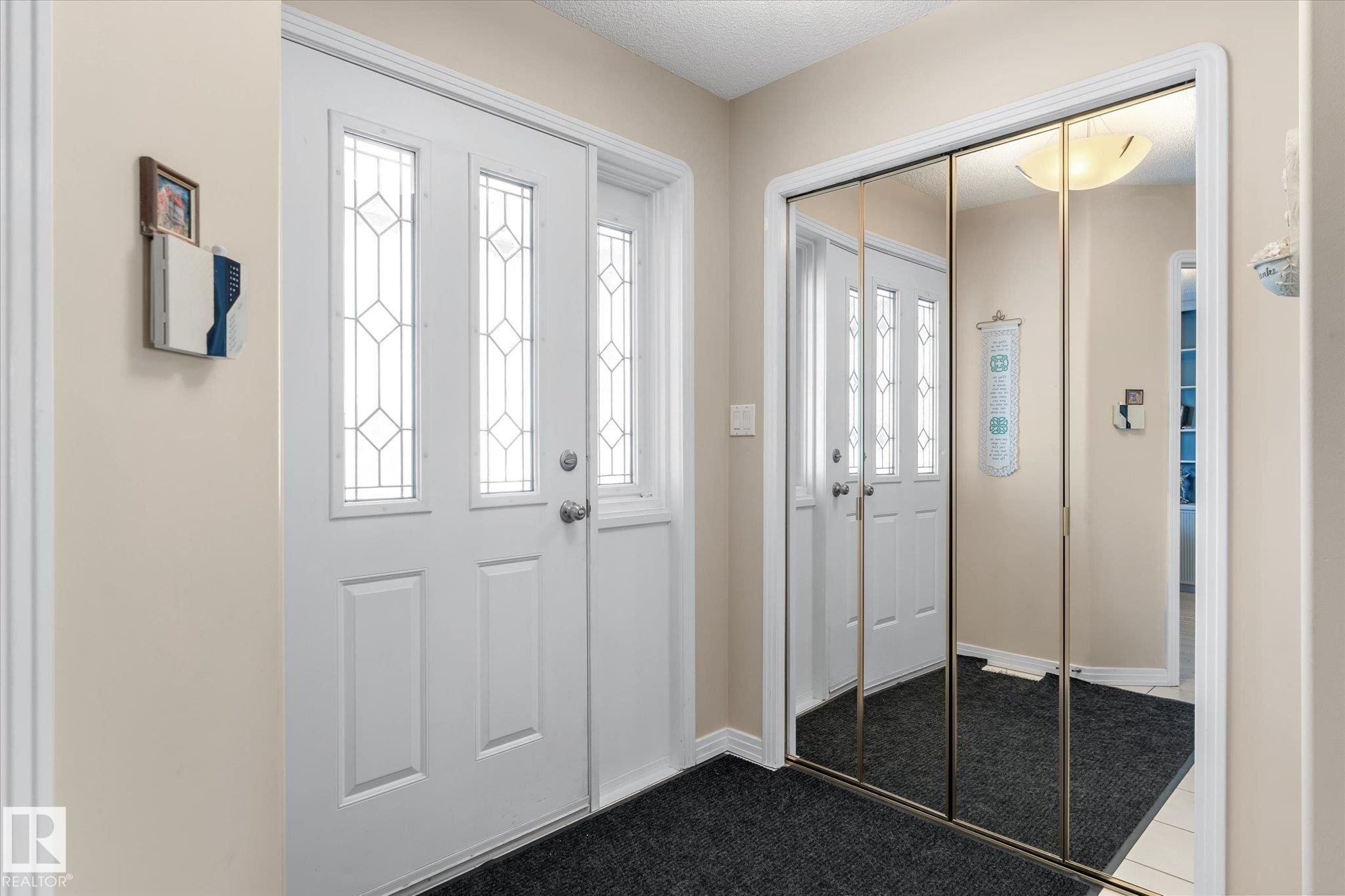 Entryway featuring a white door with decorative glass inserts, a transom window, and a full-height sidelight - 7020 157 Avenue, Edmonton, AB - Indoor Photo Showing Other Room
