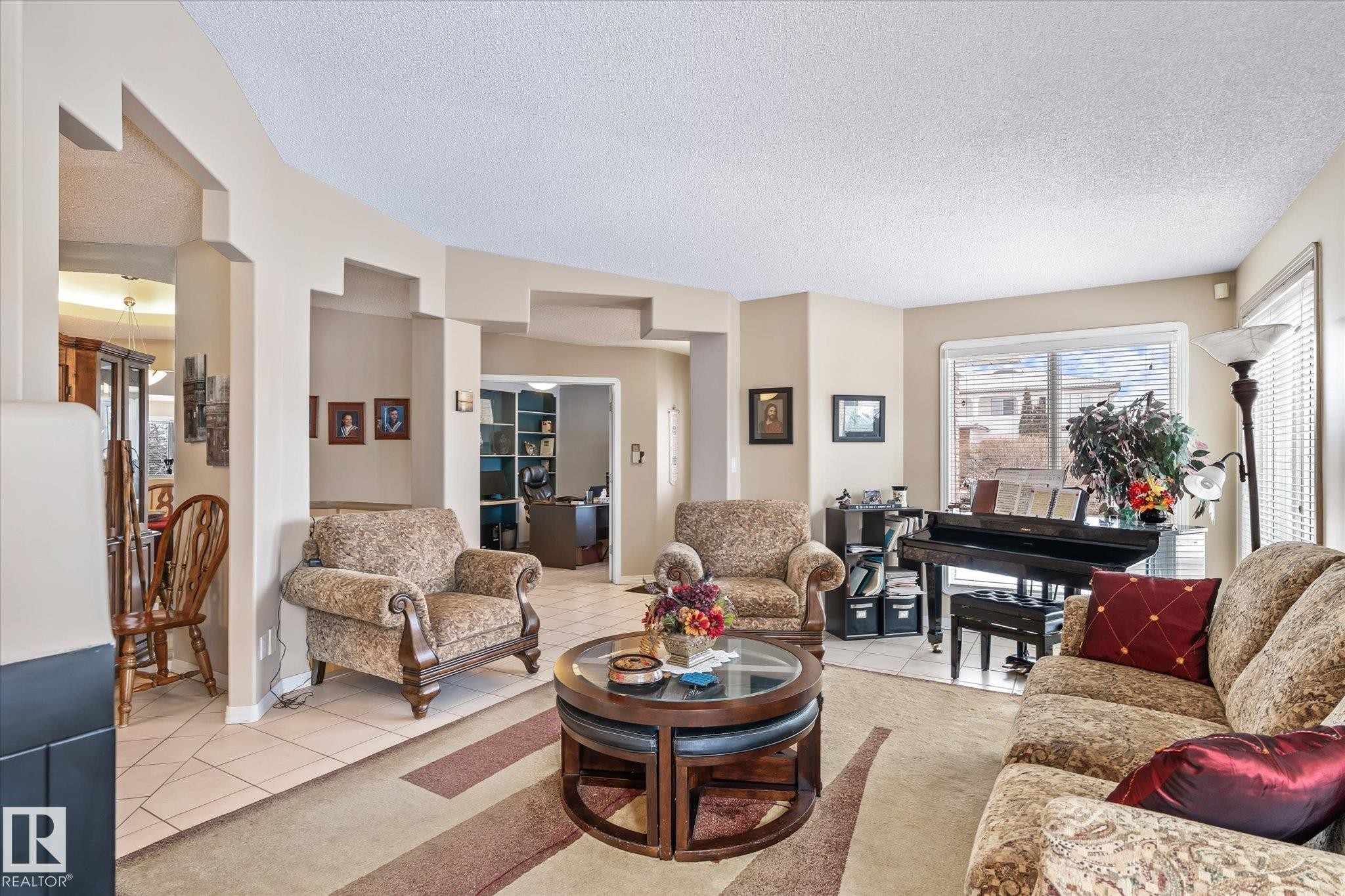Living room with a textured ceiling and light tile patterned floors - 7020 157 Avenue, Edmonton, AB - Indoor Photo Showing Living Room