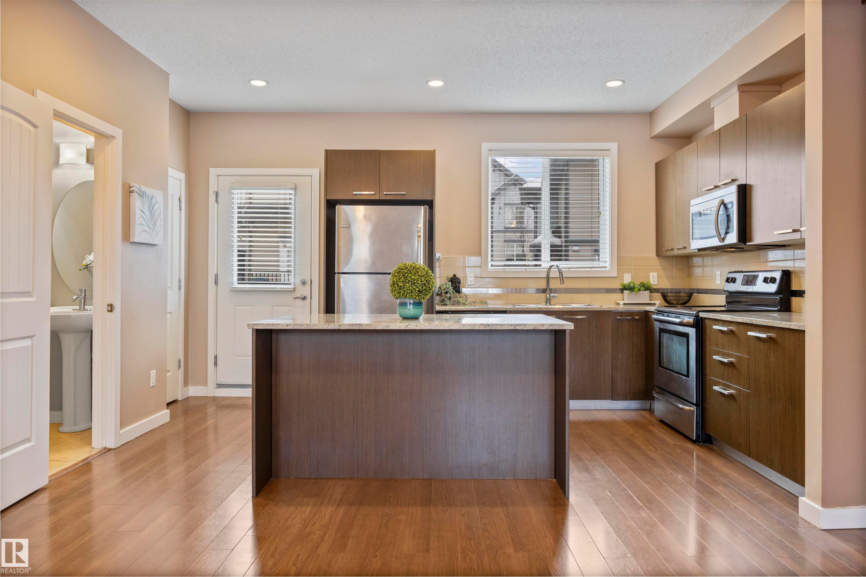 Kitchen featuring stainless steel appliances, a center island, tasteful backsplash, light wood-type flooring, and recessed lighting - 56 655 Watt Boulevard, Edmonton, AB - Indoor Photo Showing Kitchen With Stainless Steel Kitchen