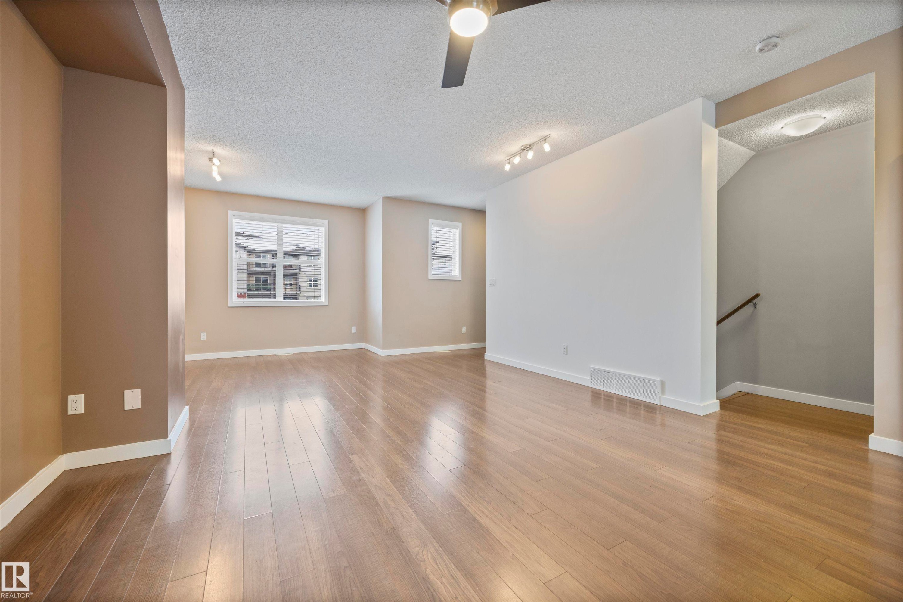 Empty room featuring a textured ceiling, light wood-style flooring, track lighting, and a ceiling fan - 56 655 Watt Boulevard, Edmonton, AB - Indoor Photo Showing Other Room