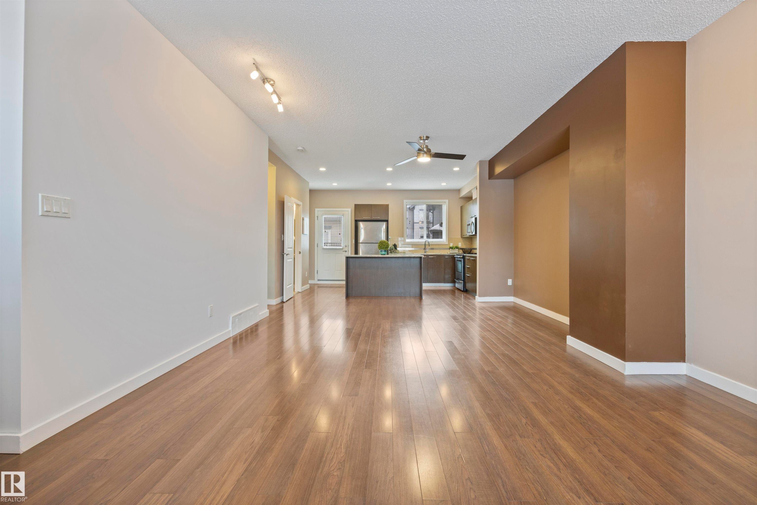 Unfurnished living room with dark wood-style floors, a textured ceiling, a ceiling fan, and recessed lighting - 56 655 Watt Boulevard, Edmonton, AB - Indoor