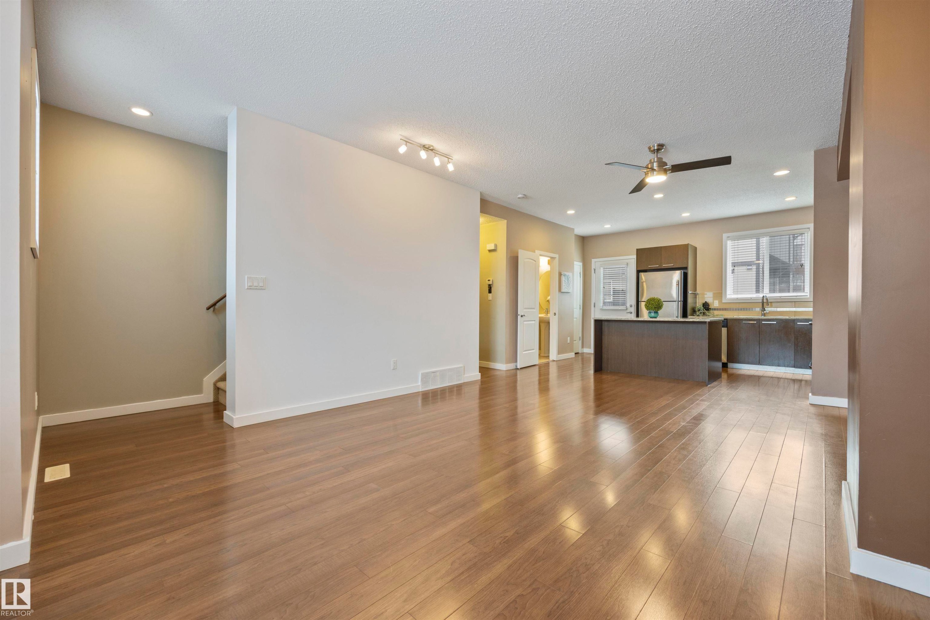 Unfurnished living room with recessed lighting, dark wood-type flooring, a textured ceiling, and ceiling fan - 56 655 Watt Boulevard, Edmonton, AB - Indoor